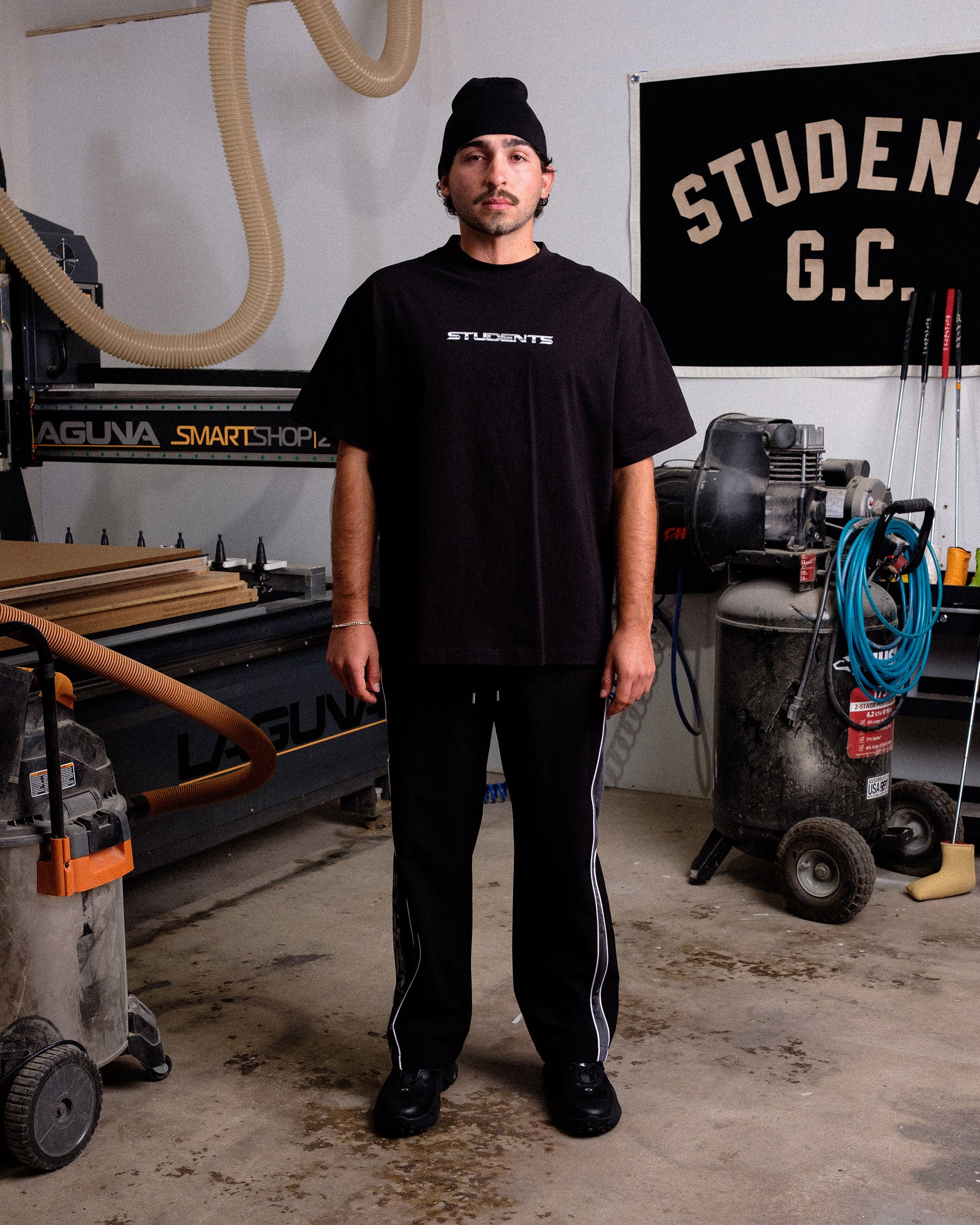 Person wearing a black 'STUDENTS' t-shirt in a workshop setting