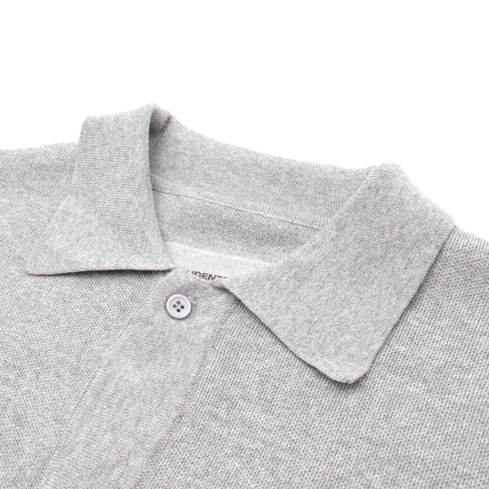 Close-up of a gray polo shirt collar with a button on a white background