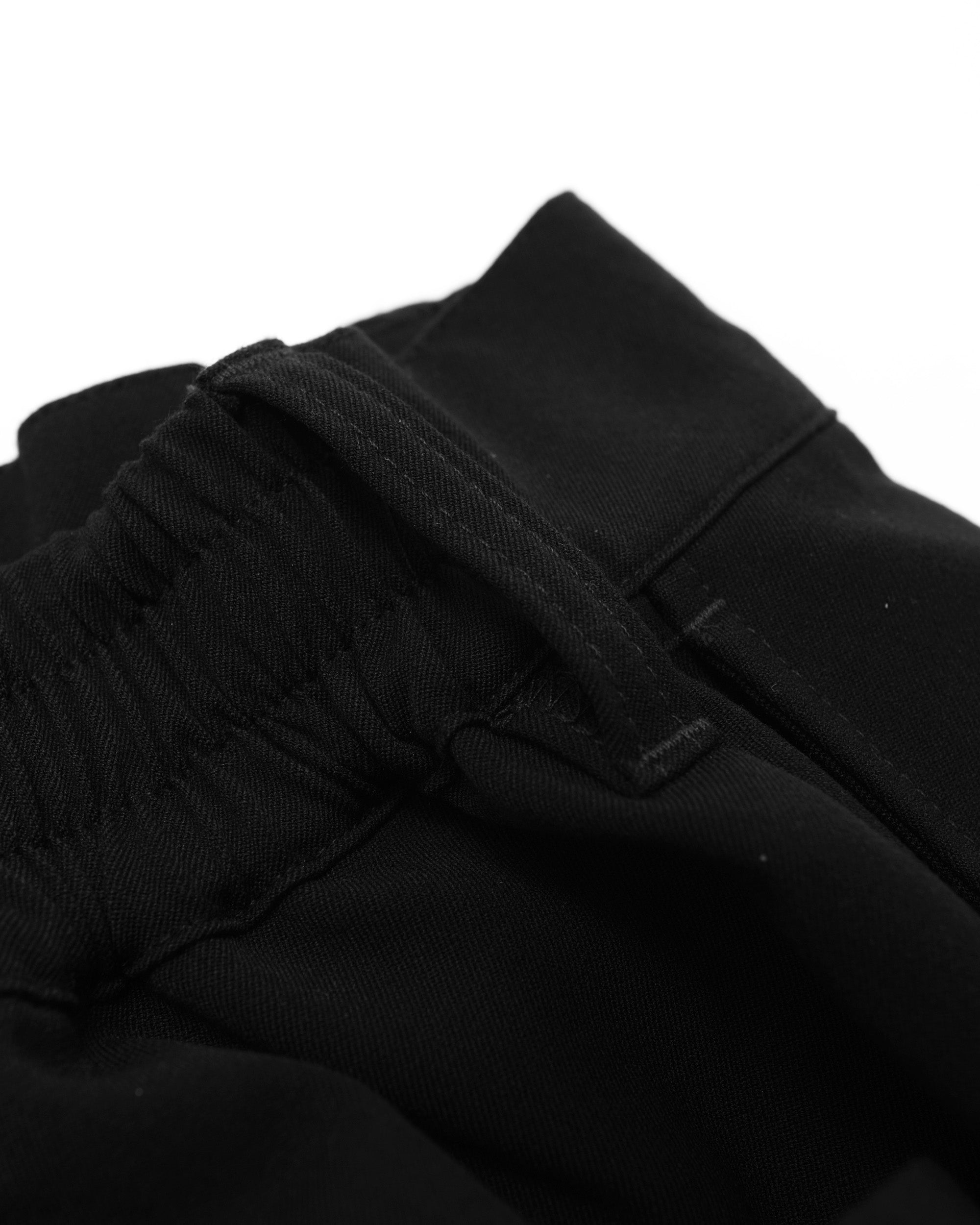 Close-up of black pants with a white background