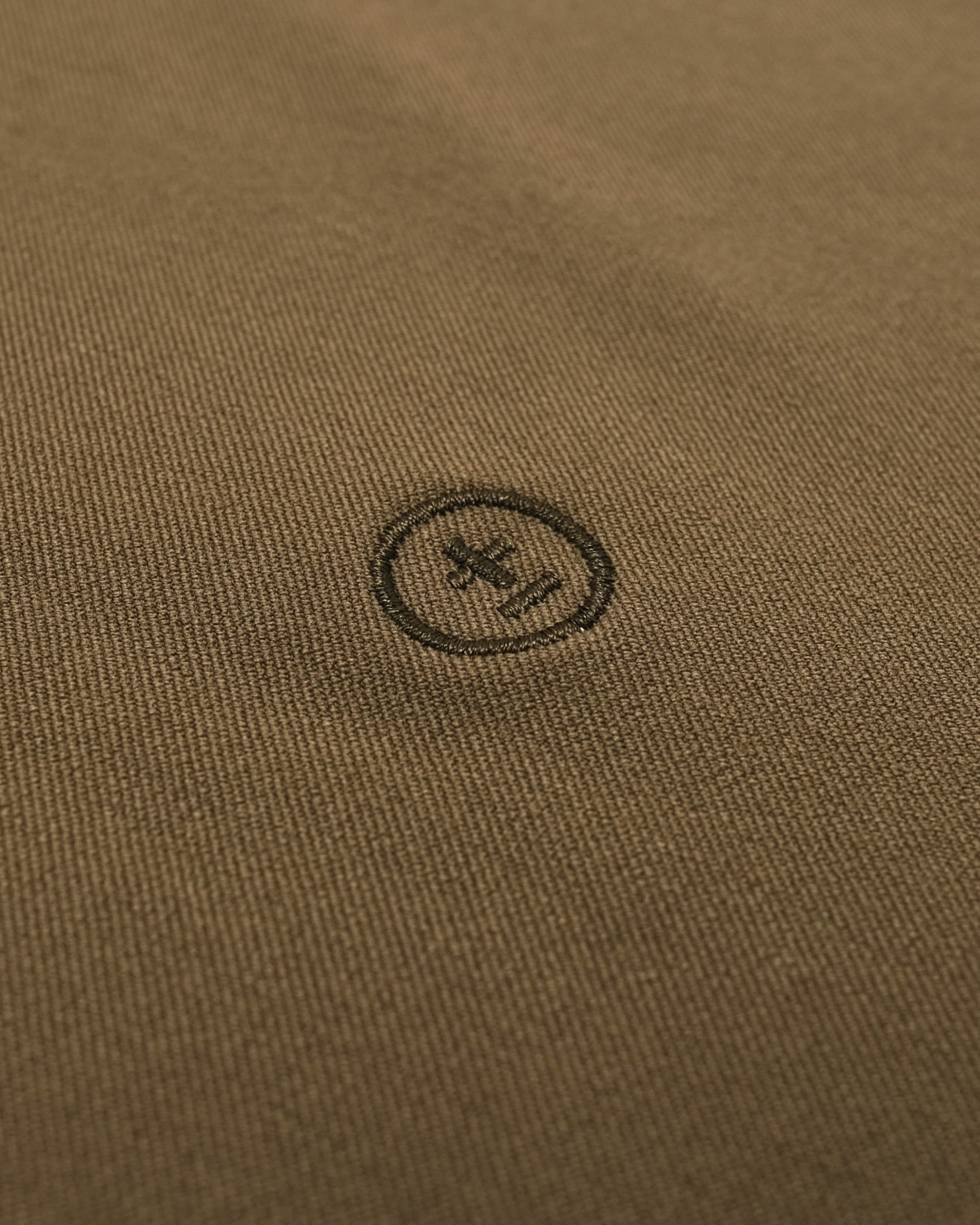 Close-up of a brown fabric with a small logo or brand emblem.
