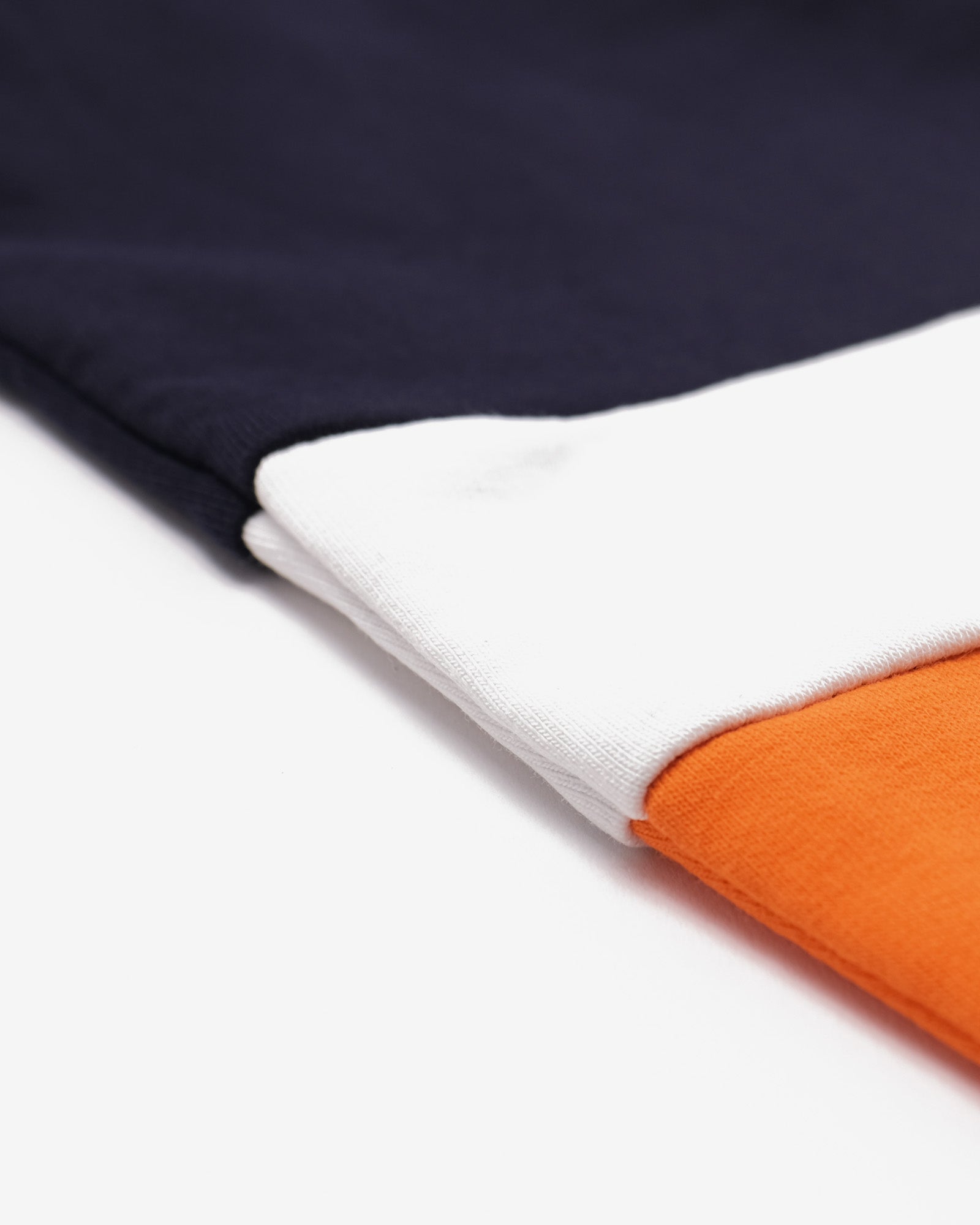 Close-up of fabric with navy, white, and orange colors on a white background