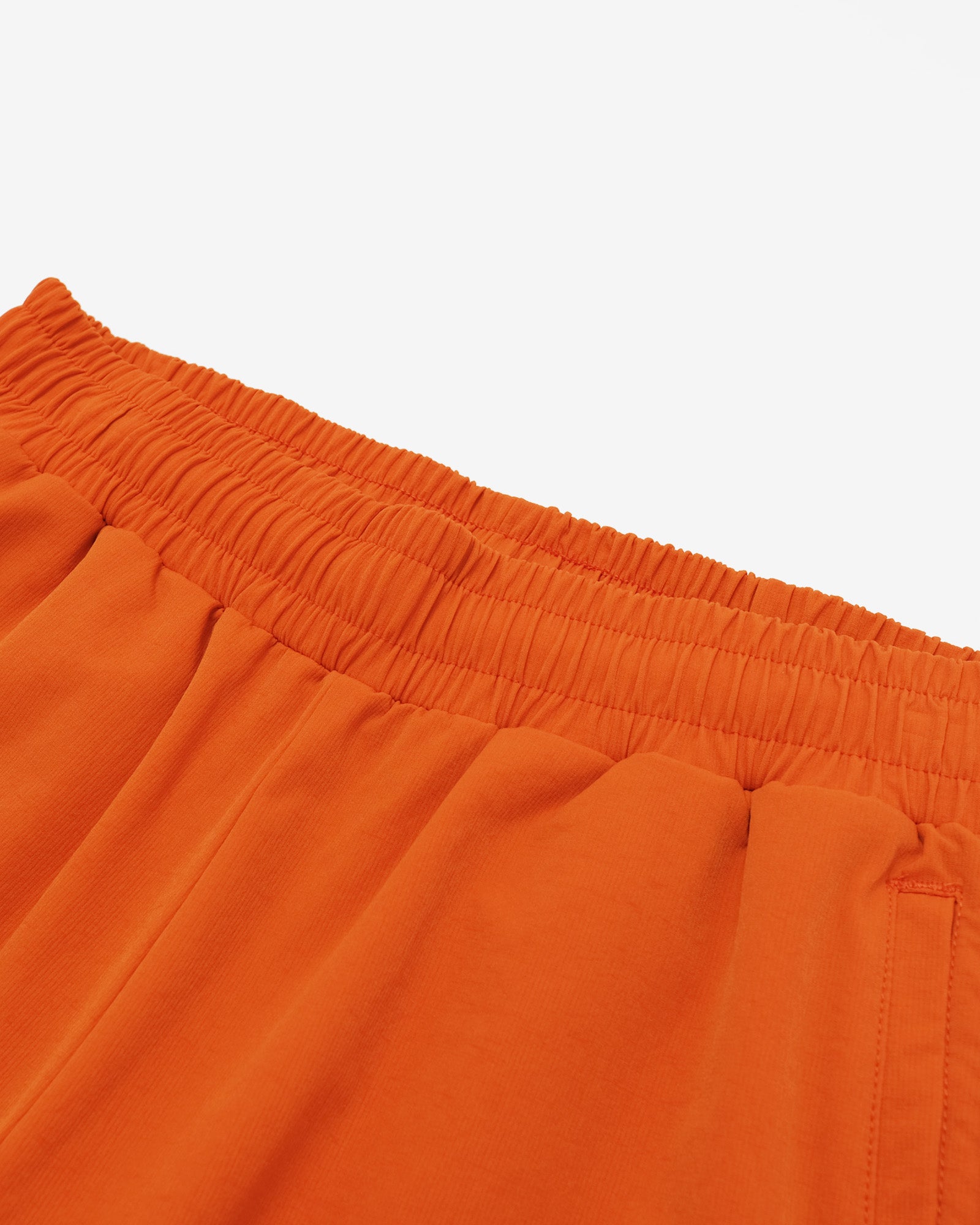 Close-up of orange shorts with a white background