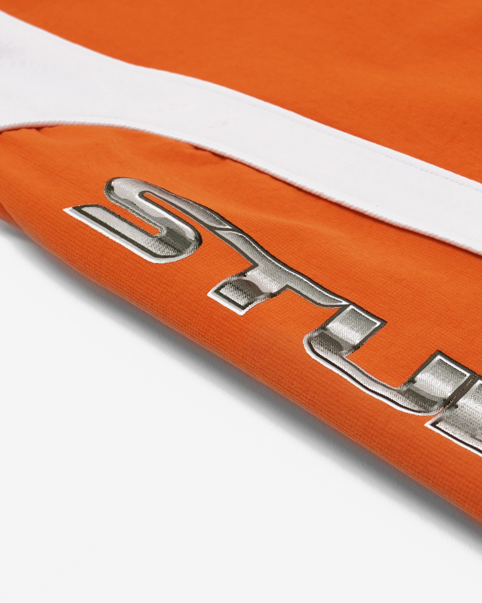 Close-up of a metallic 'STUDENTS' logo on an orange background