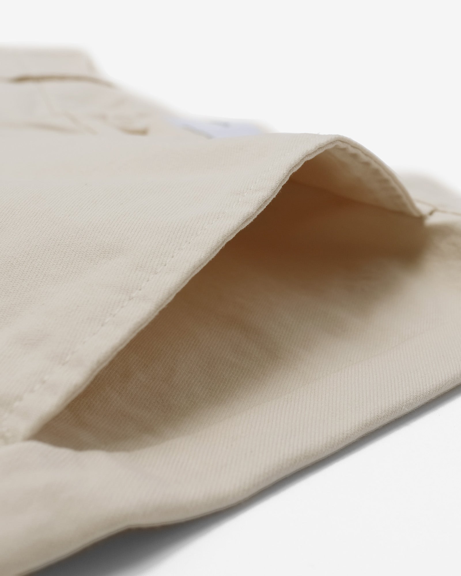 Close-up of beige fabric with a subtle texture on a white background
