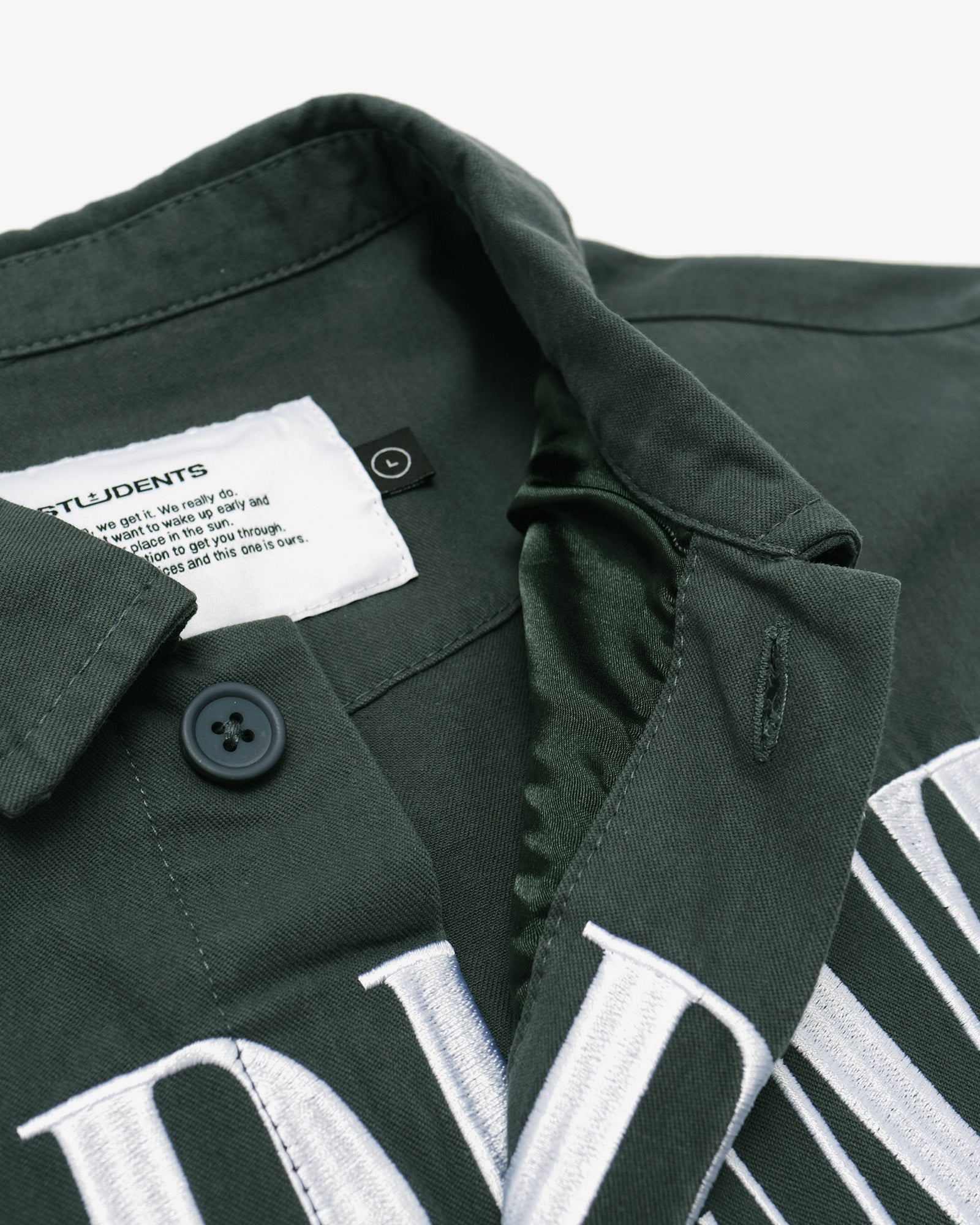 Green jacket with white text and button details on a light gray background