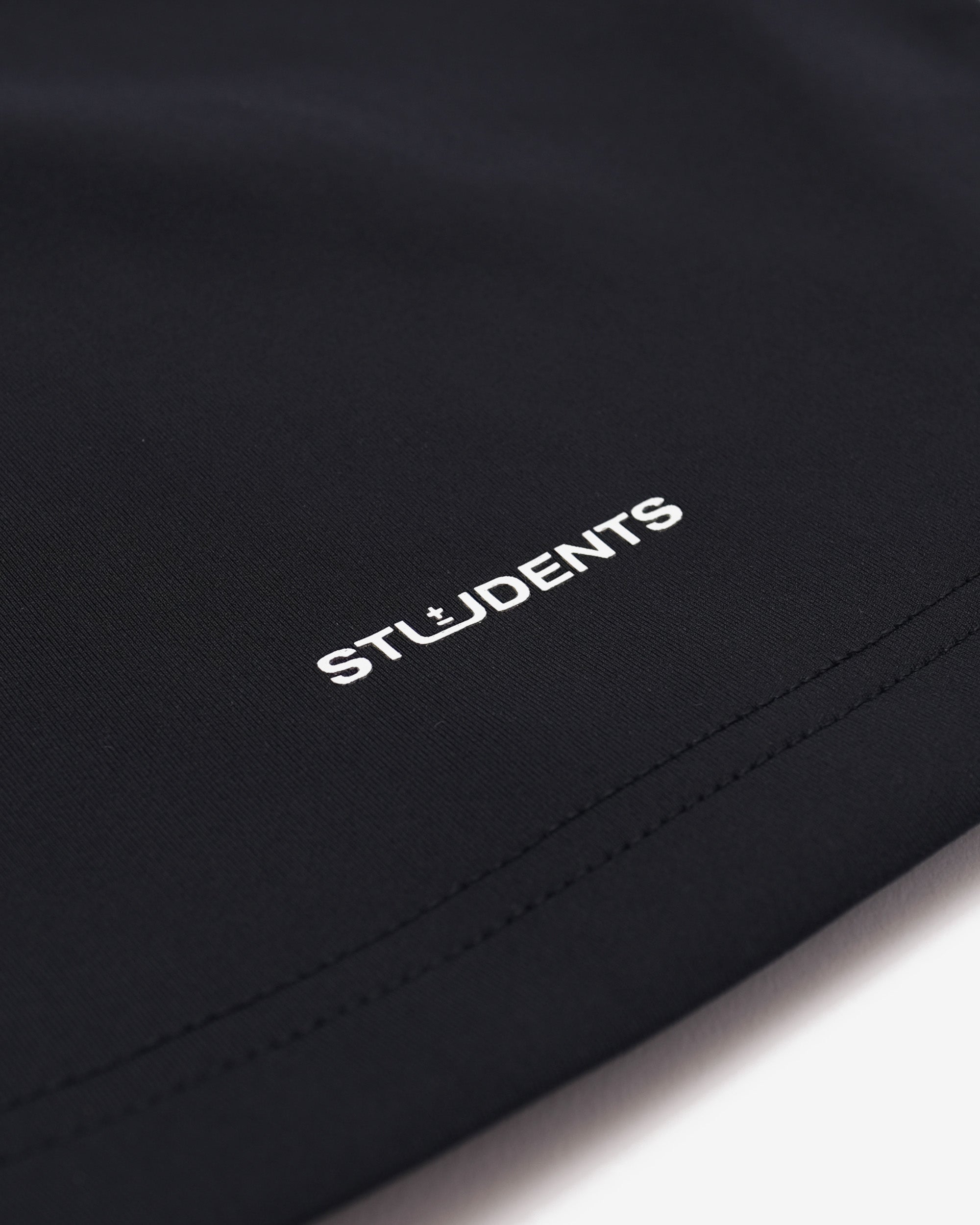 Black fabric with 'STUDENTS' embroidered in white on a white background