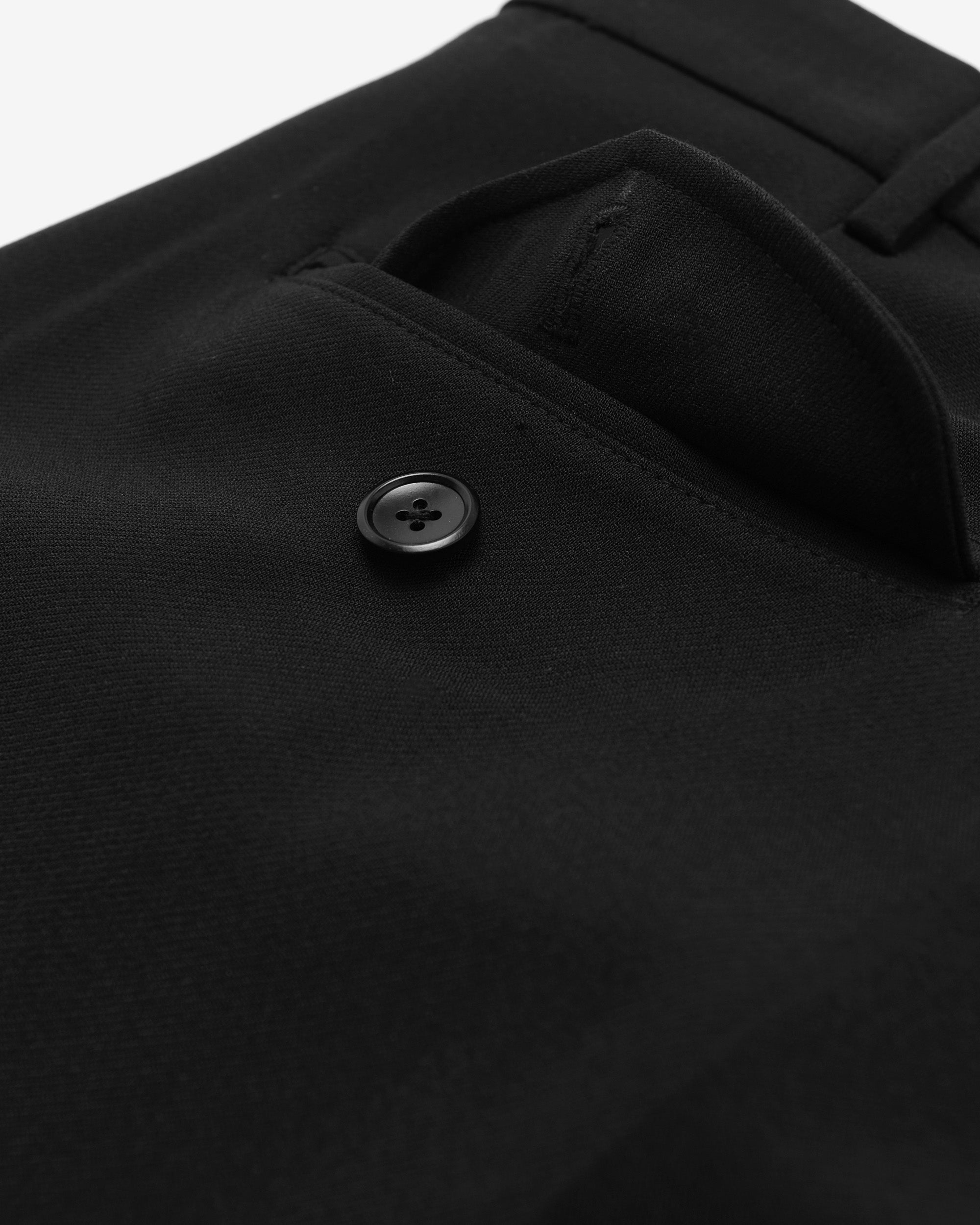 Close-up of a black coat with a button on a white background