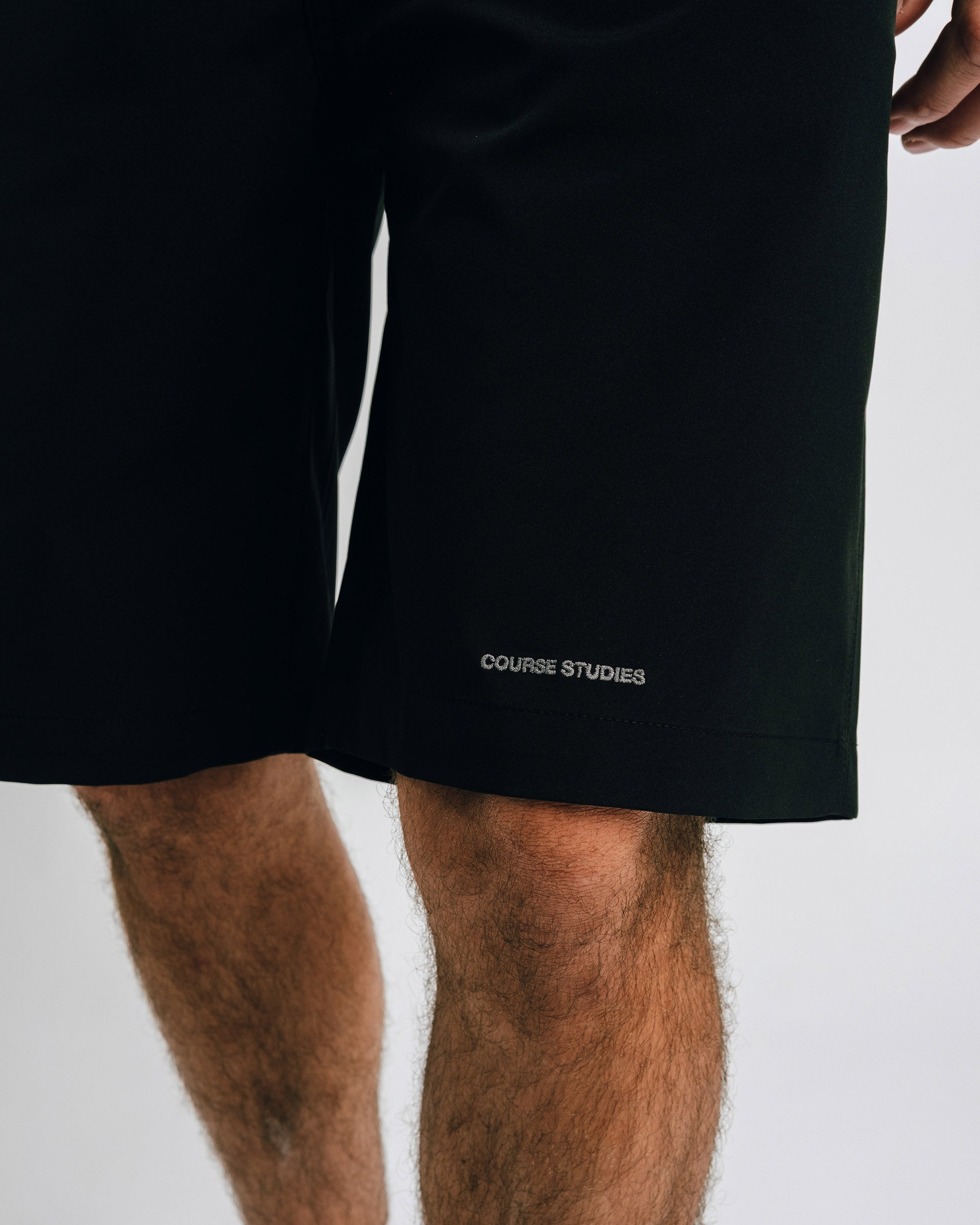 Black shorts with 'COURSE STUDIES' branding on a white background