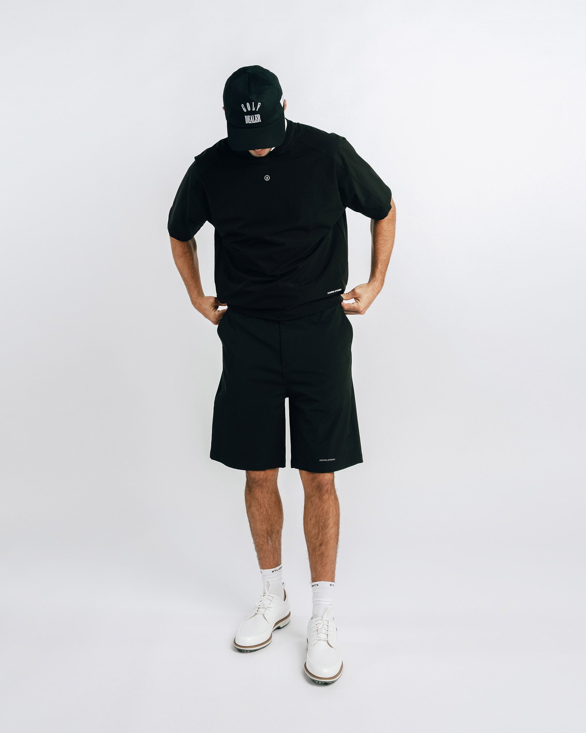 Person wearing a black outfit with a cap on a white background