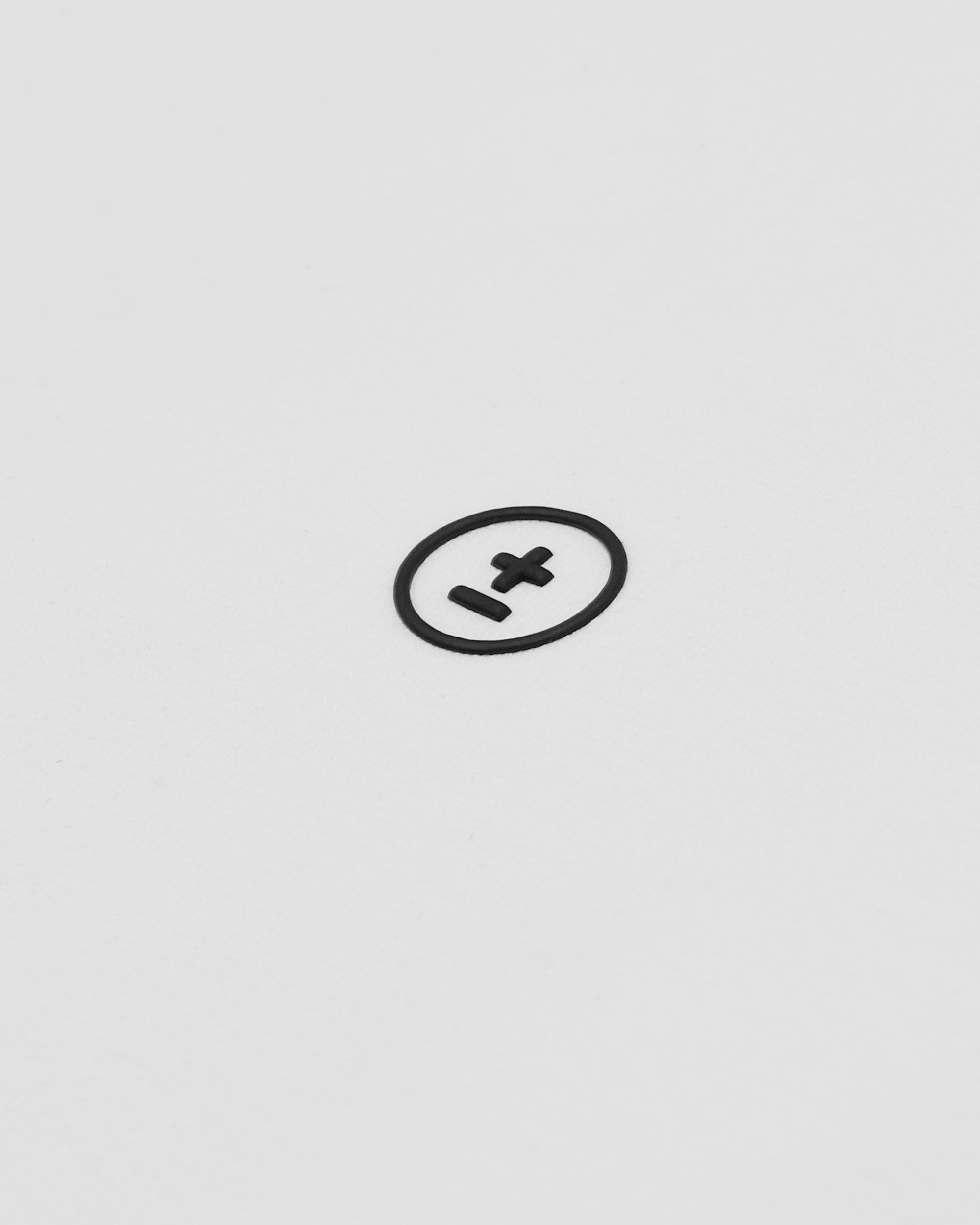 Black circle with a plus sign on a light gray background