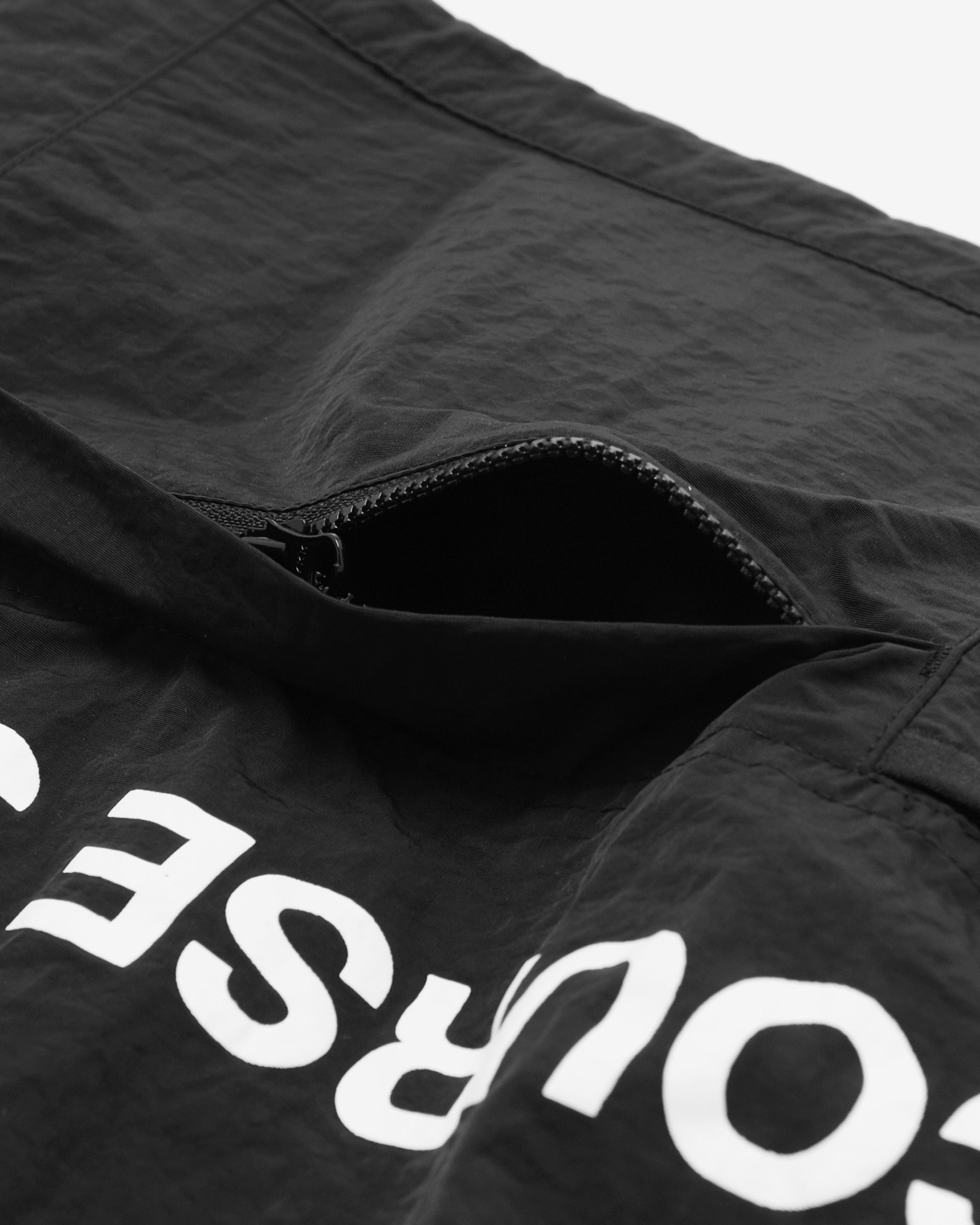 Black jacket with white text on a close-up of the zipper area