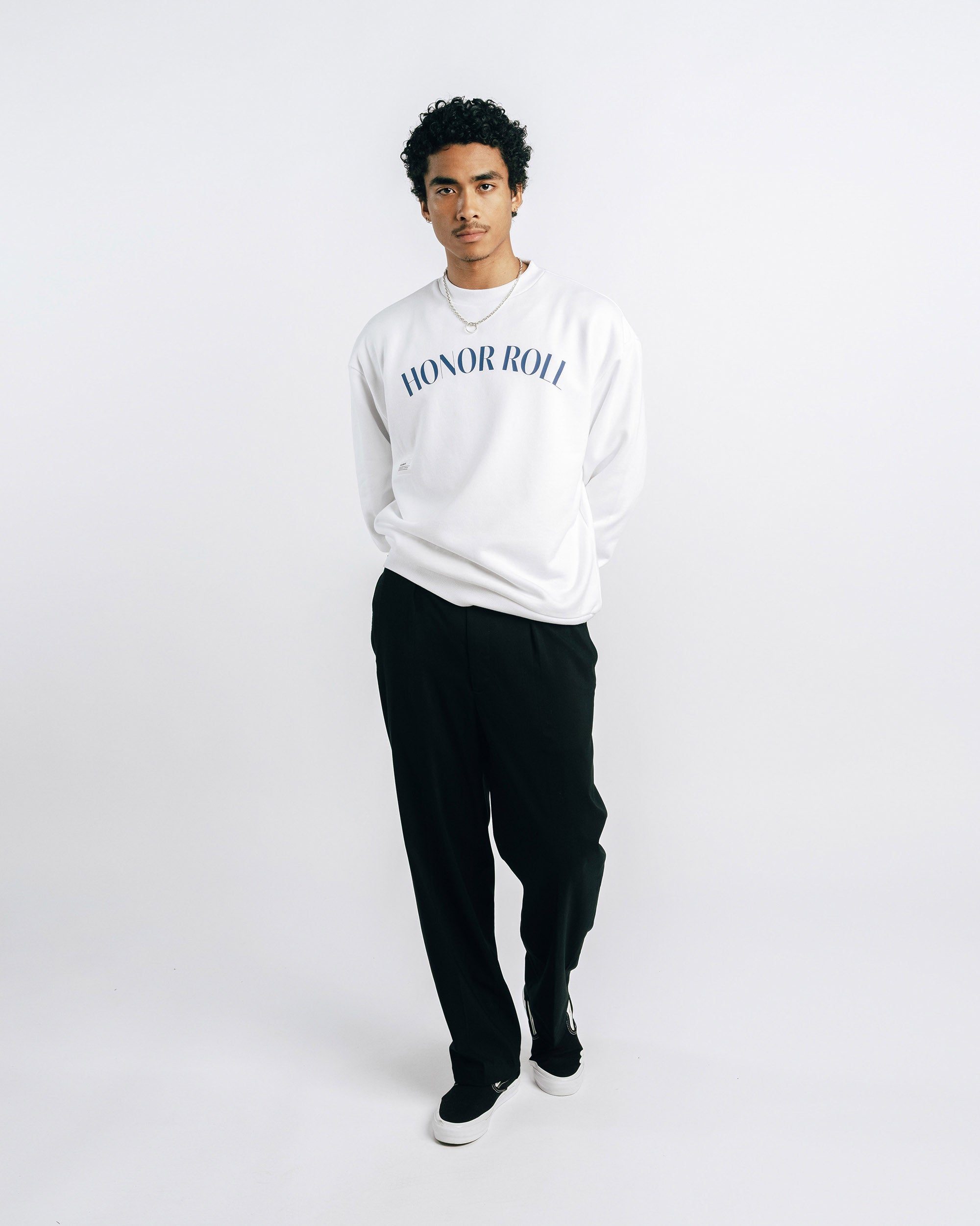 Person wearing a white sweatshirt with 'Honor Roll' text on a plain background