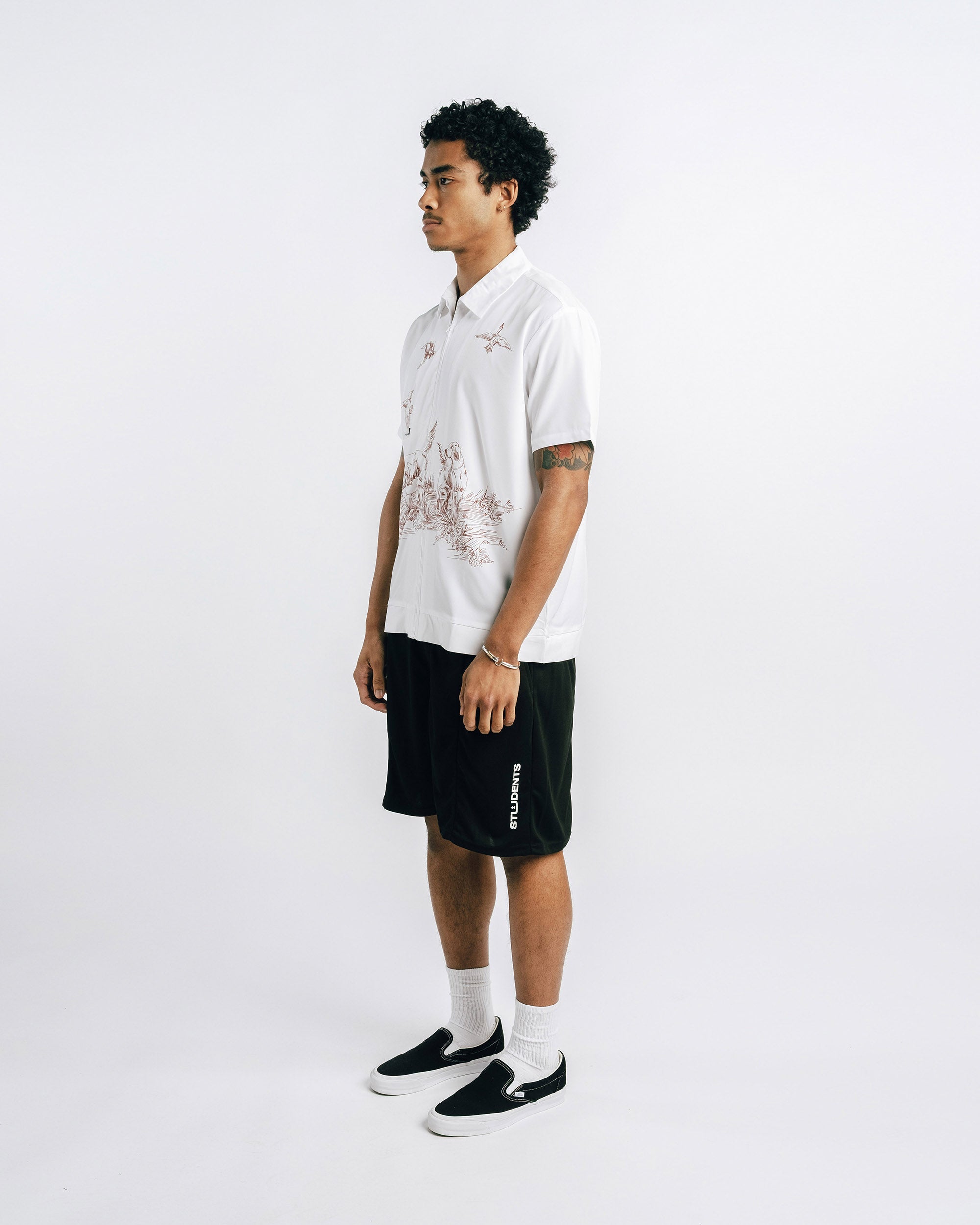 Person wearing a white shirt with black shorts on a white background