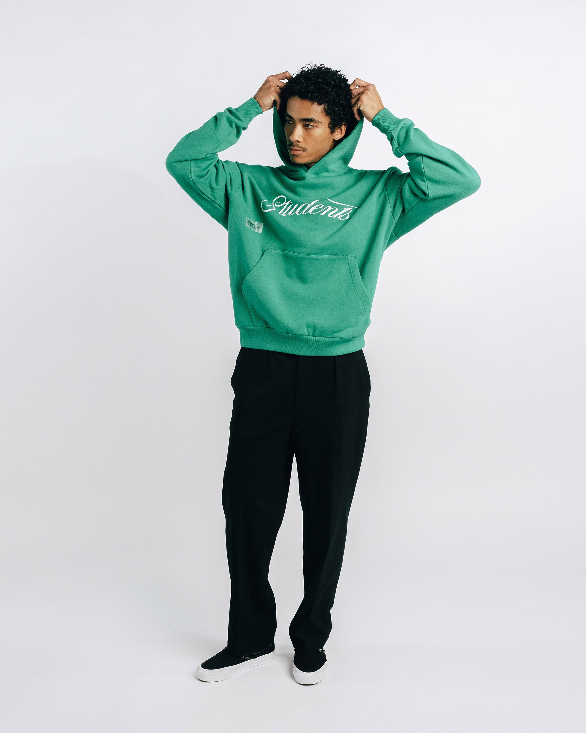 Person wearing a green hoodie with text on a white background