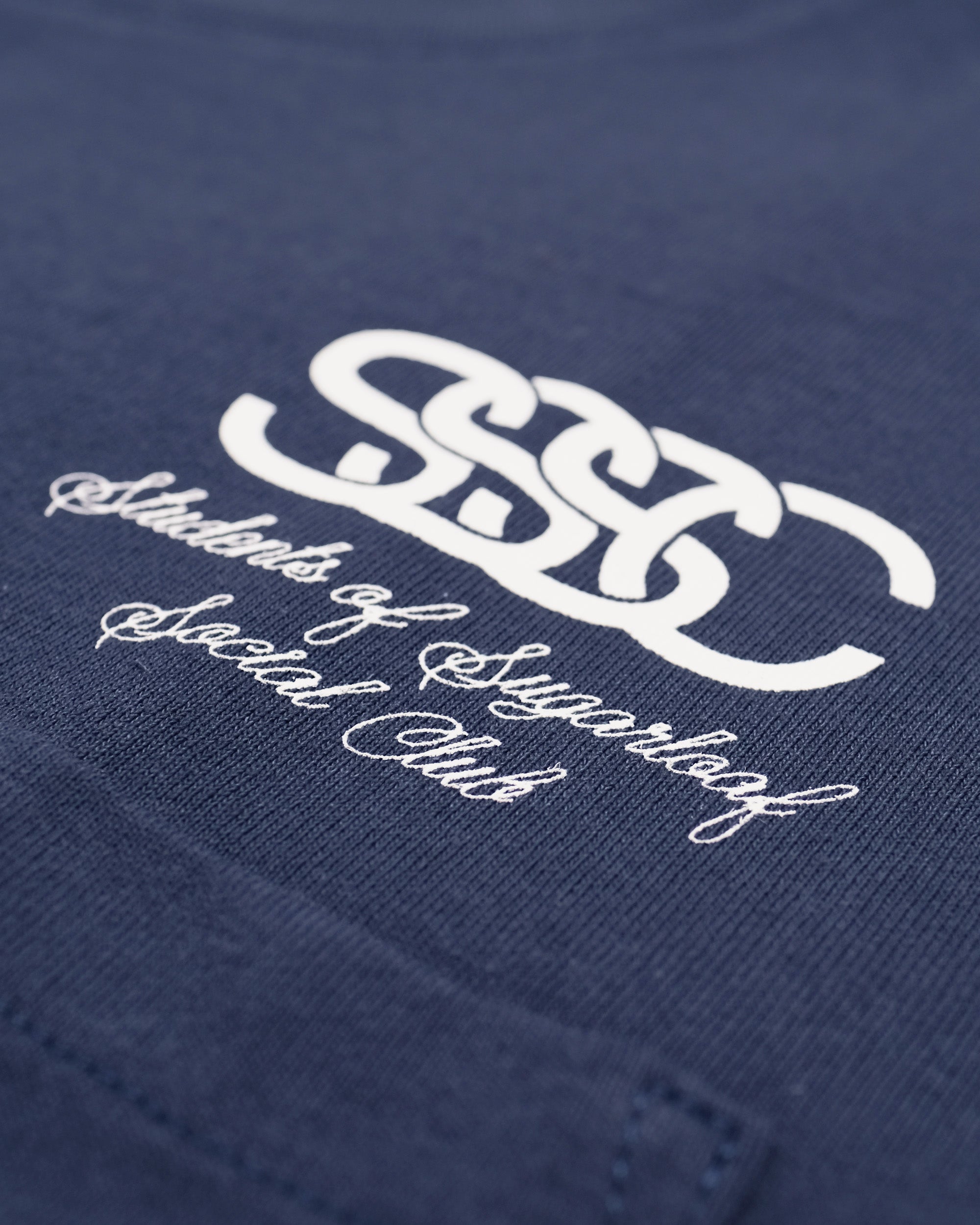Navy blue shirt with white logo and text on a plain background