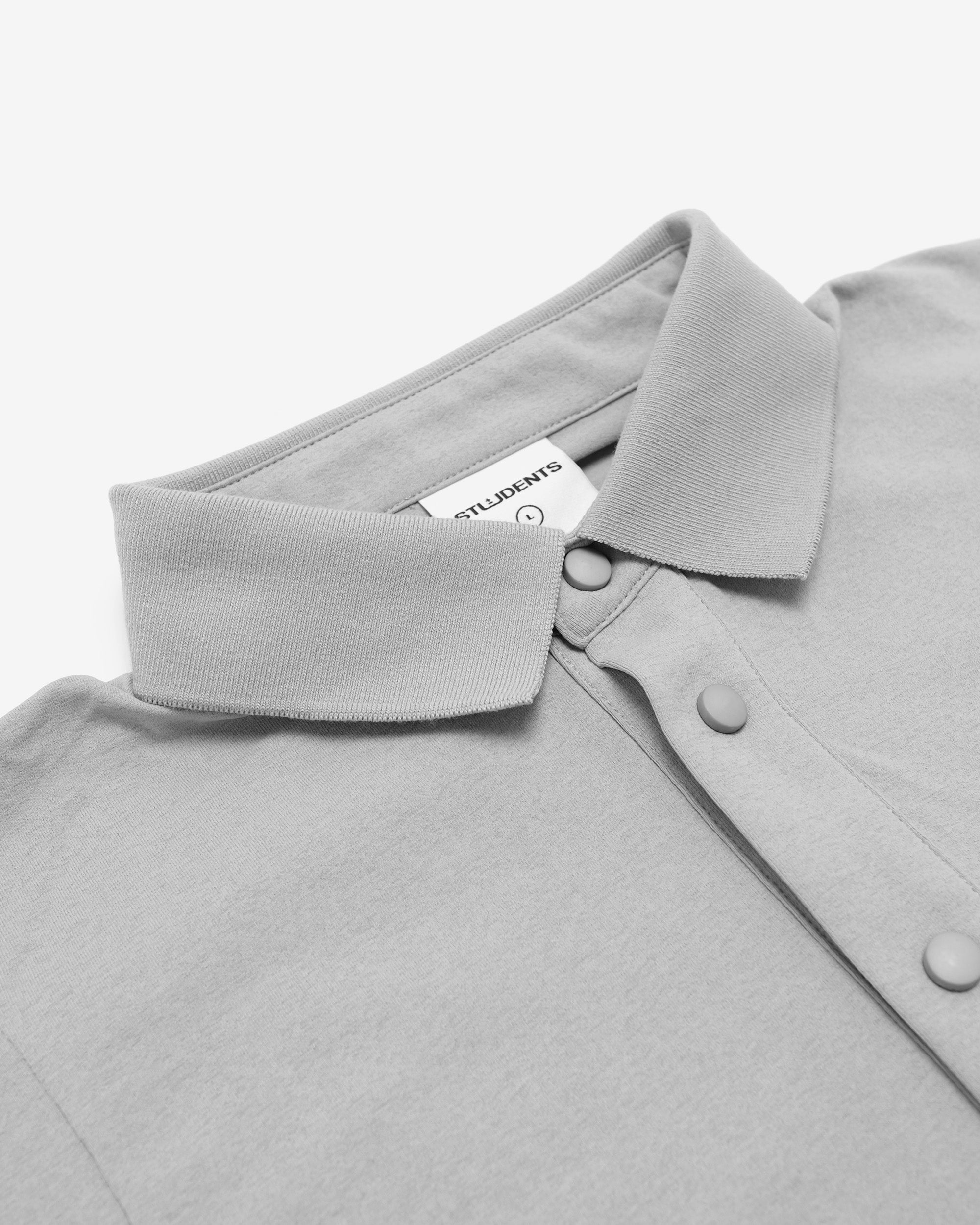 Close-up of a gray shirt collar with a brand label on a white background