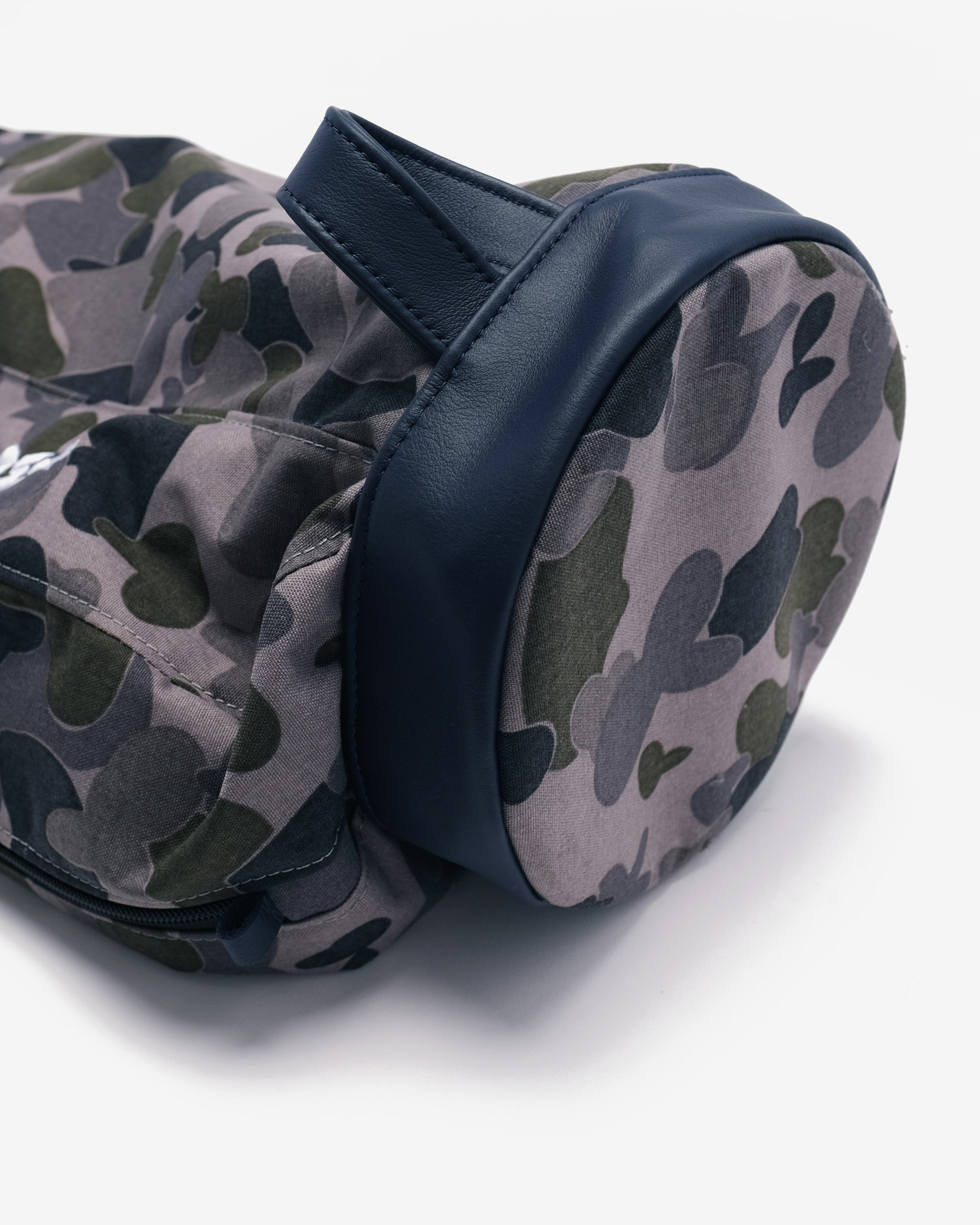 Camouflage-patterned bag with a navy strap on a white background