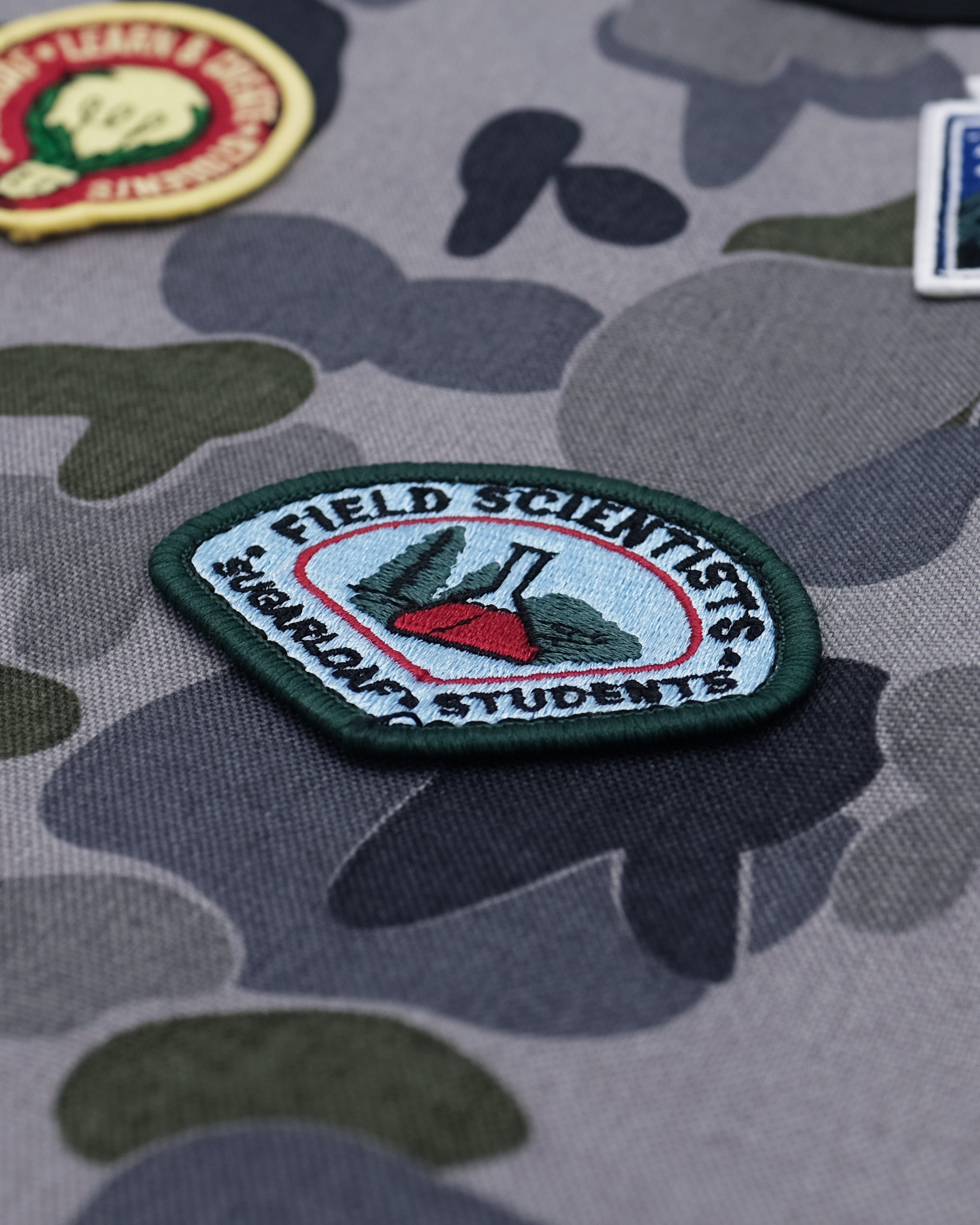 Patch on camouflage fabric with 'Field Scientists' text