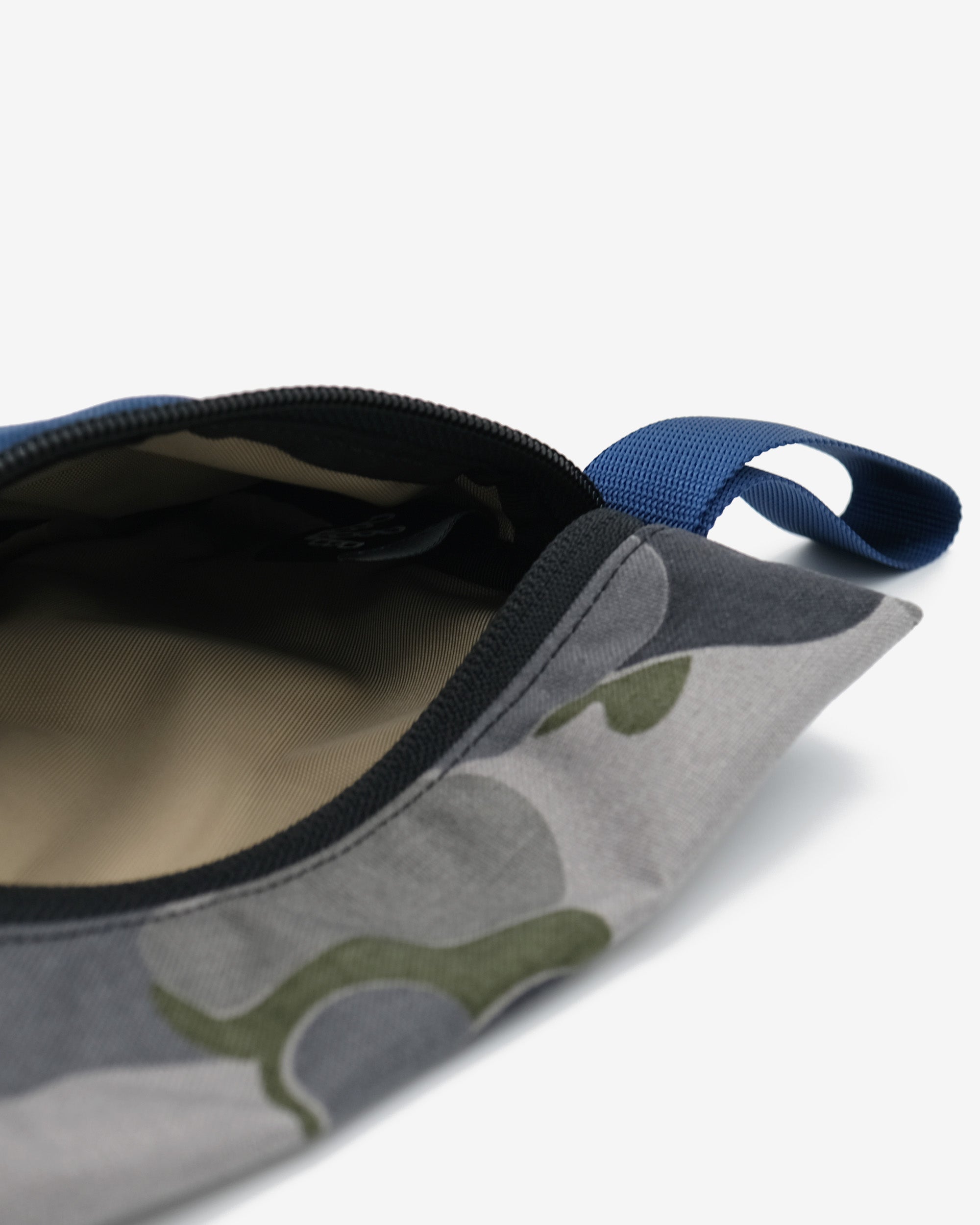 Close-up of a fabric pouch with a camouflage pattern on a white background