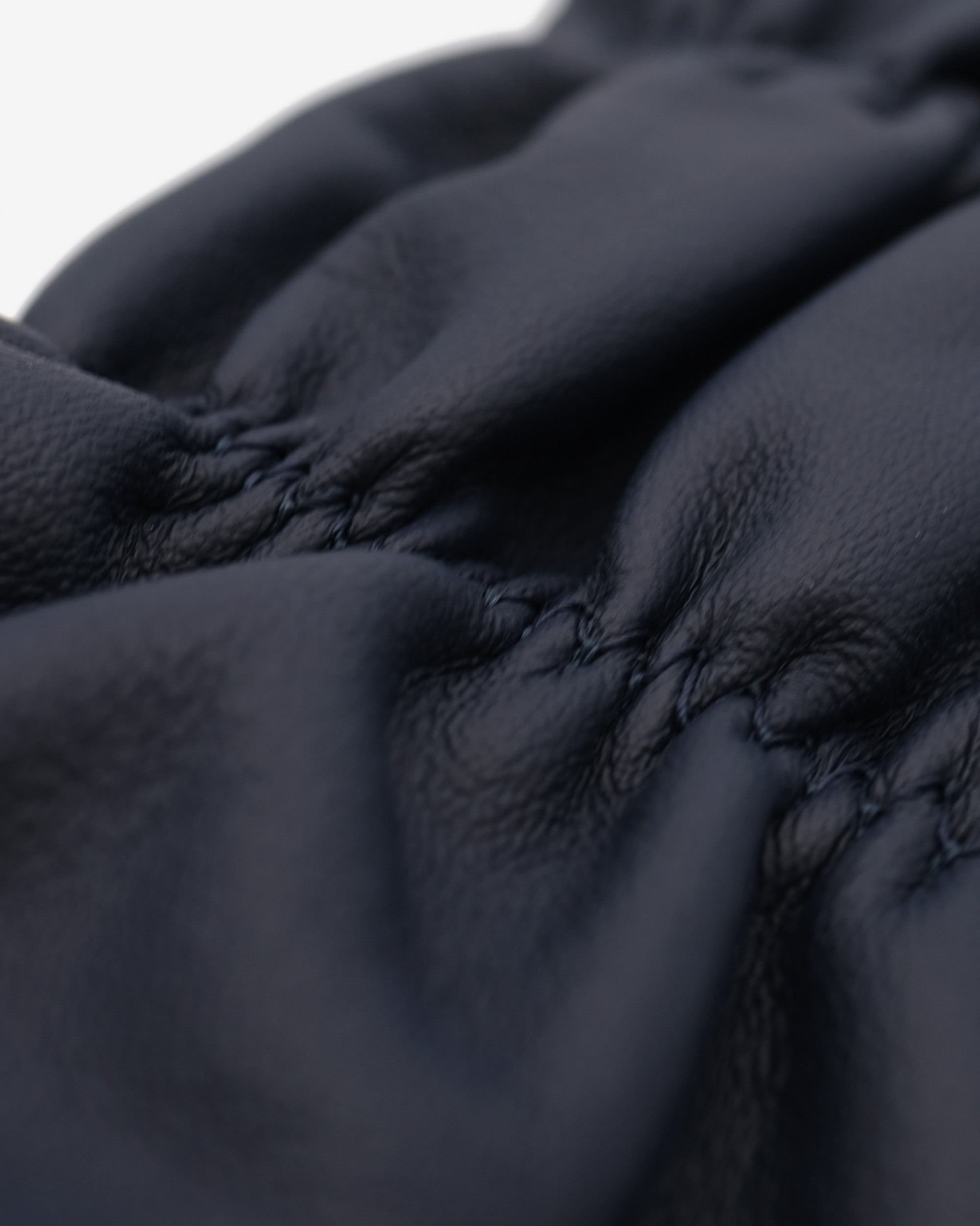 Close-up of a dark blue fabric with visible stitching details.