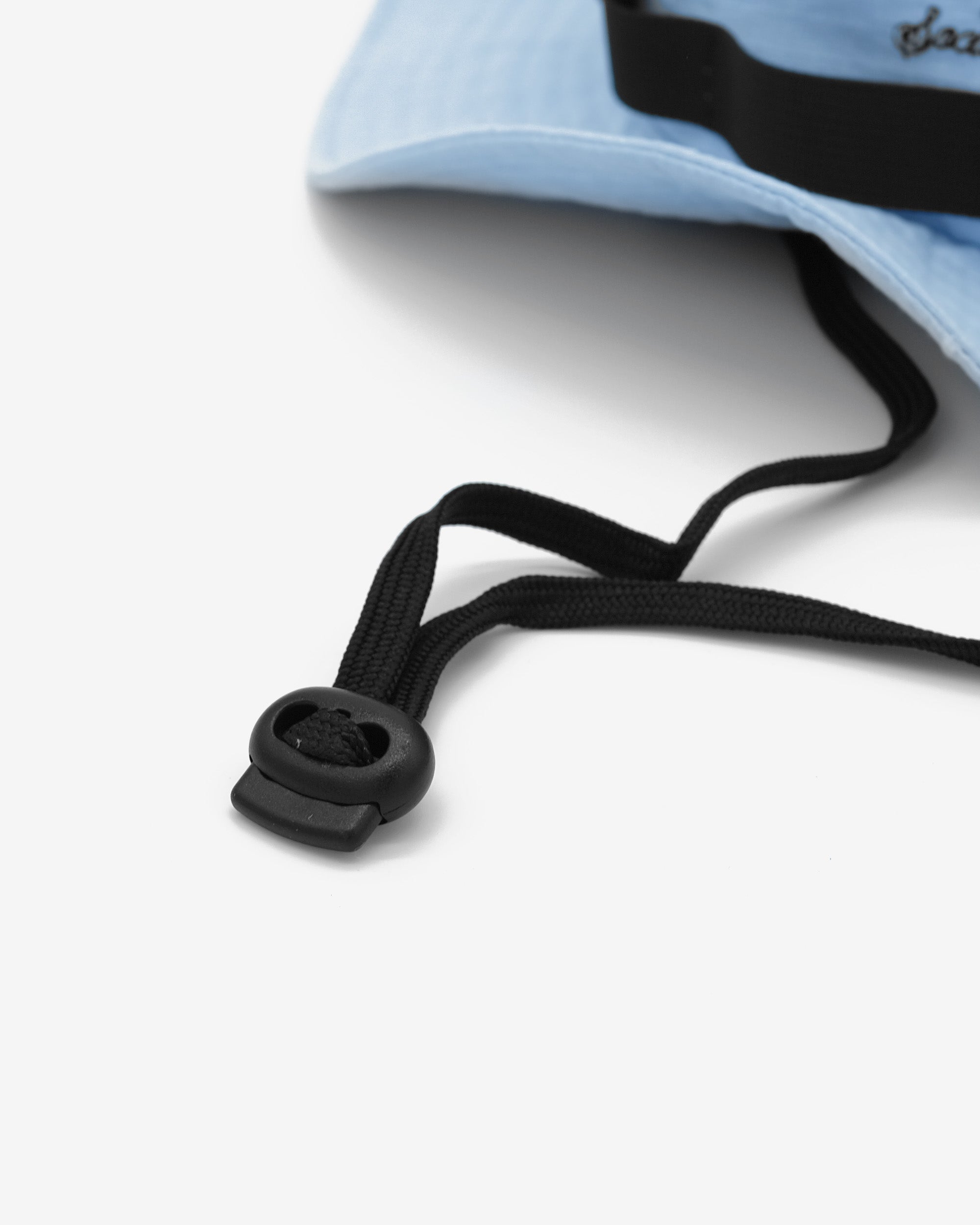 Close-up of a blue drawstring with a black cord on a white background