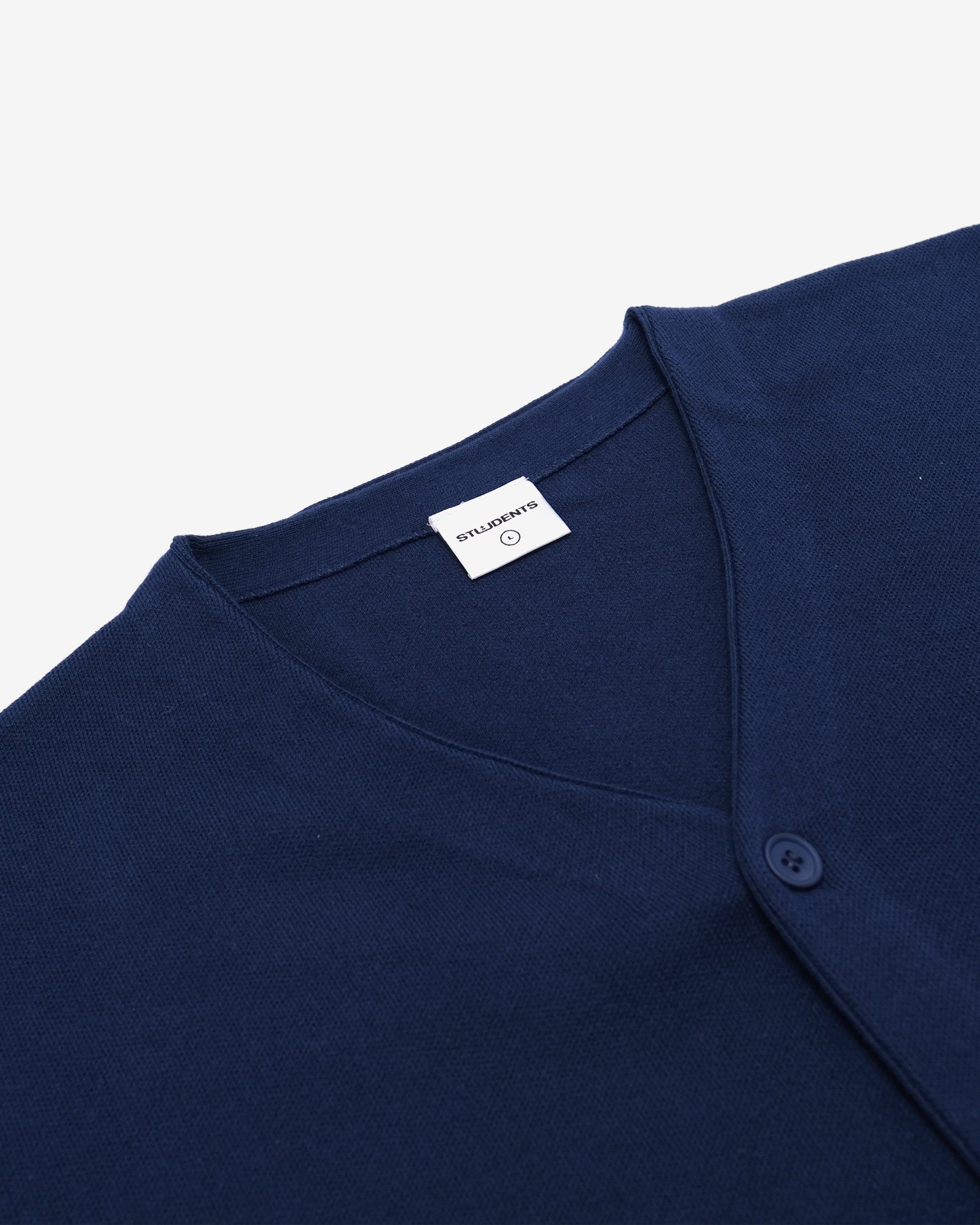 Close-up of a navy blue garment with a brand label on a light gray background