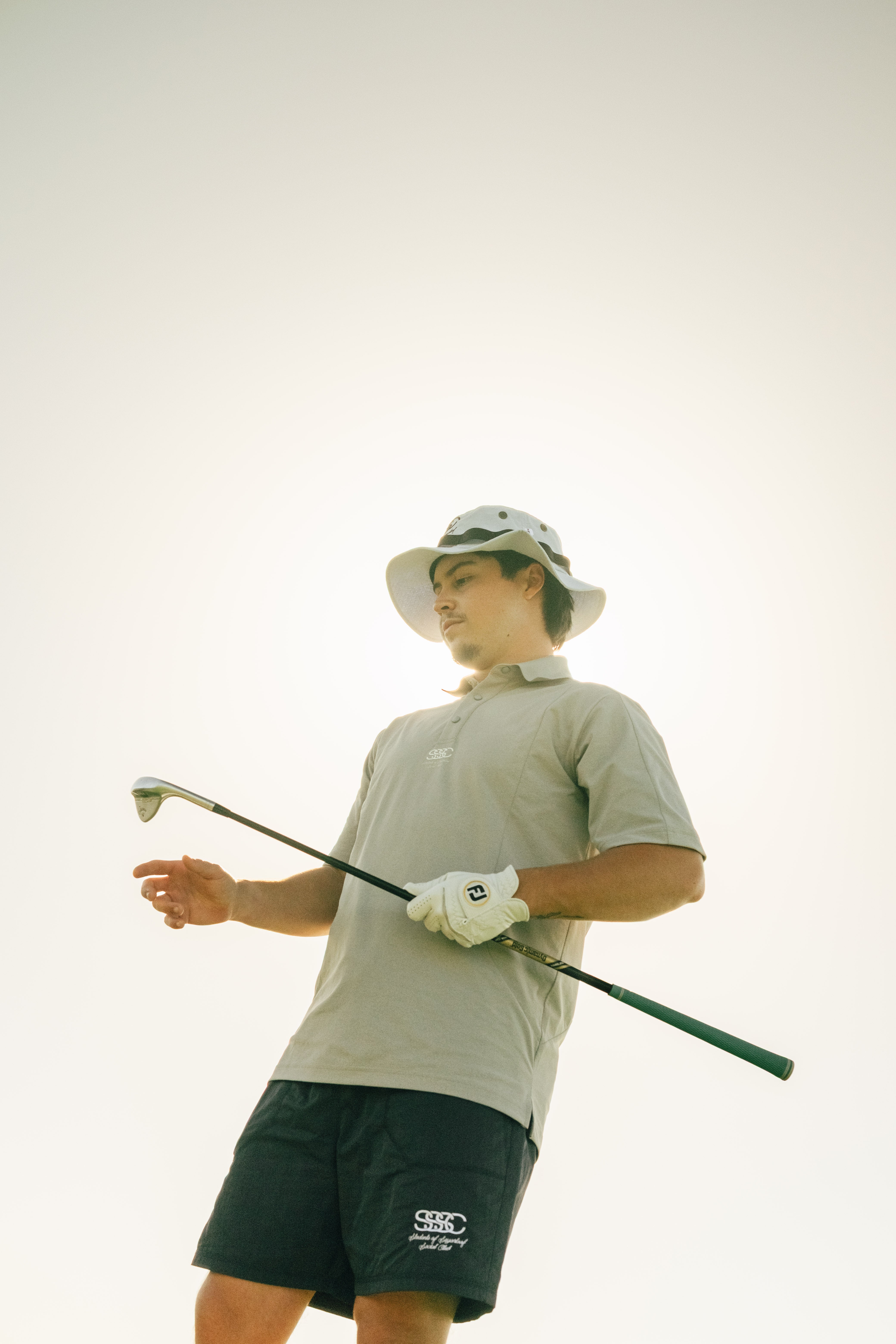 Man holding a golf club against a plain background