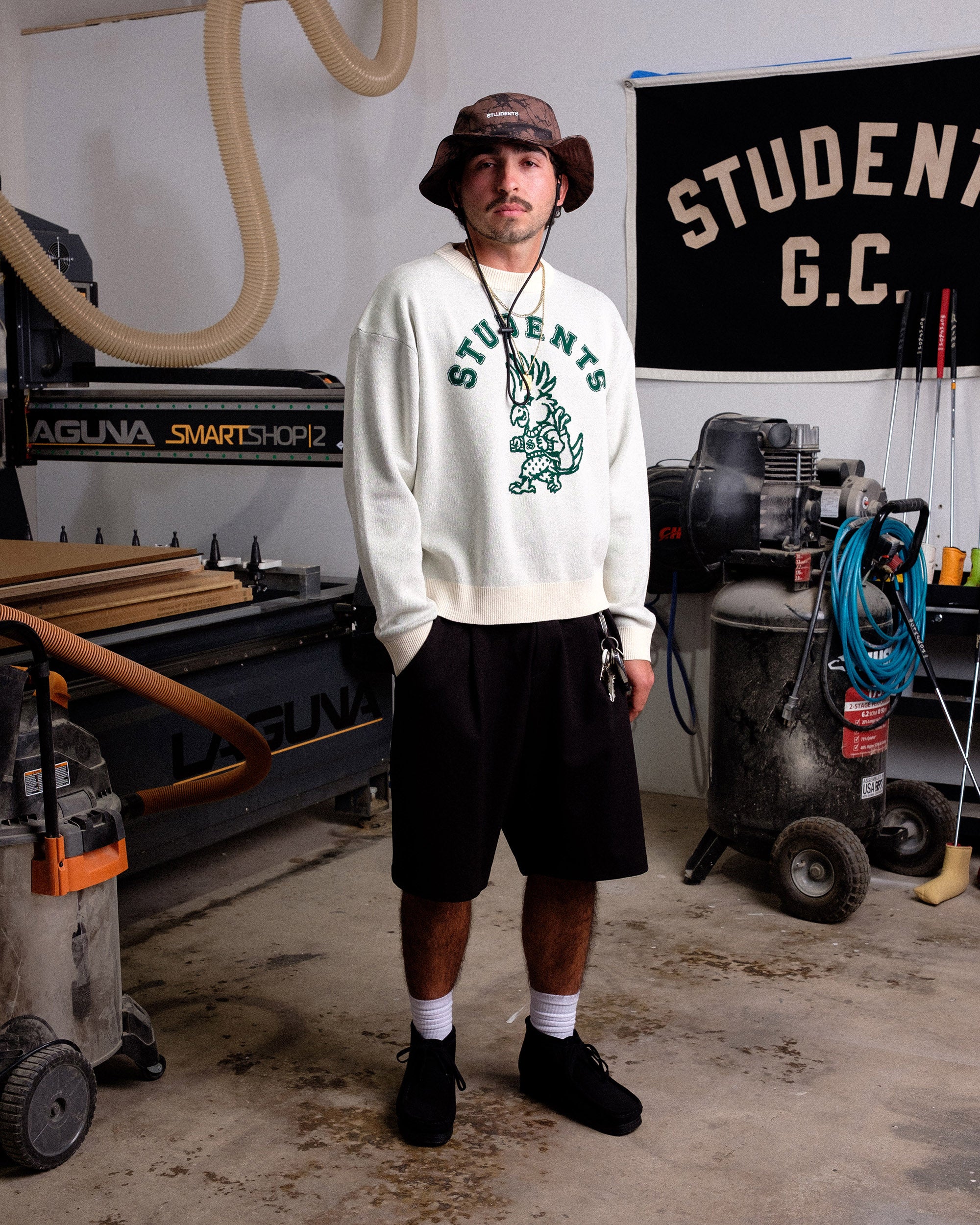 Person wearing a sweatshirt with 'STUDENTS' printed on it in a workshop setting.