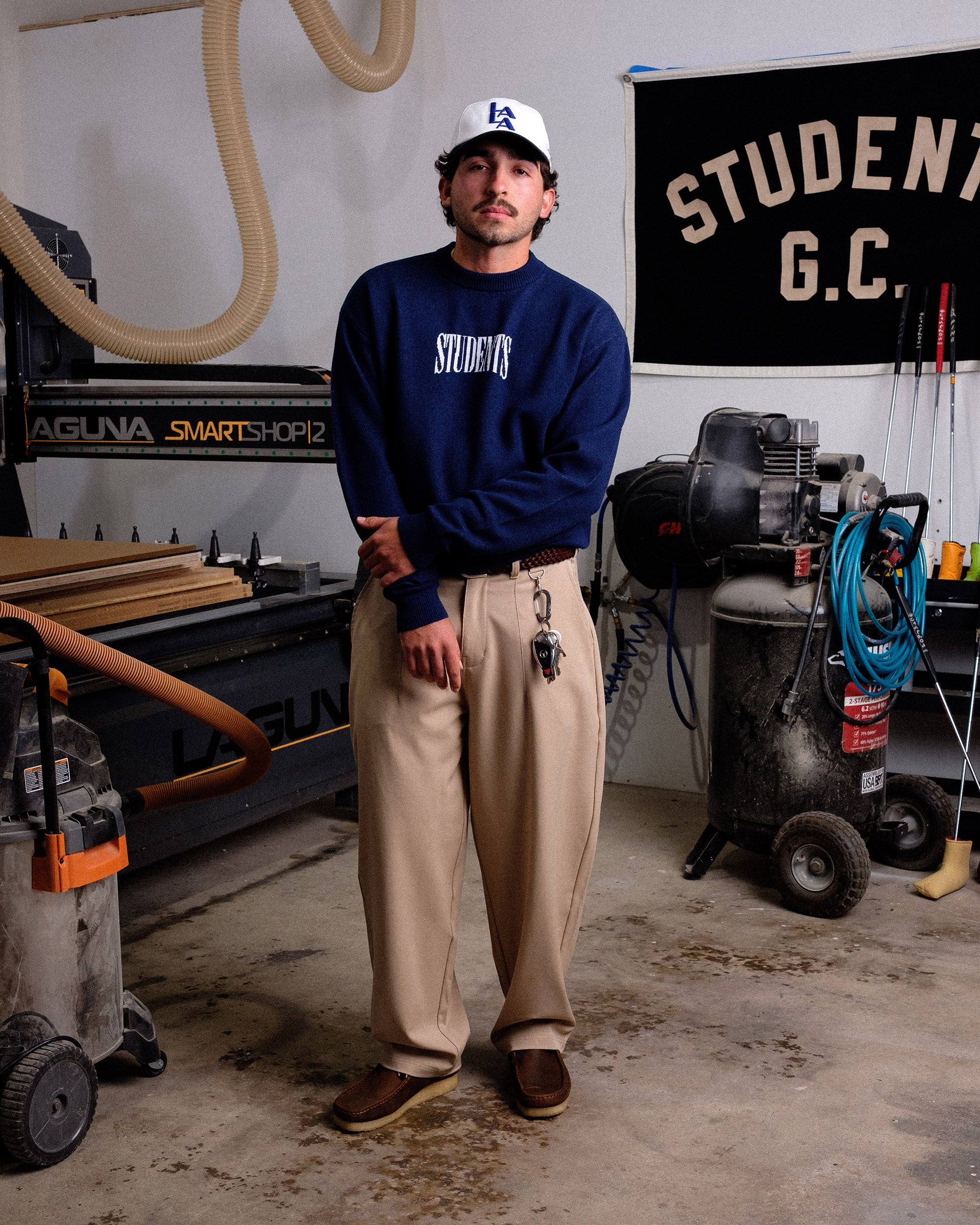 Person wearing a navy sweatshirt with 'STUDENT' text in a workshop setting