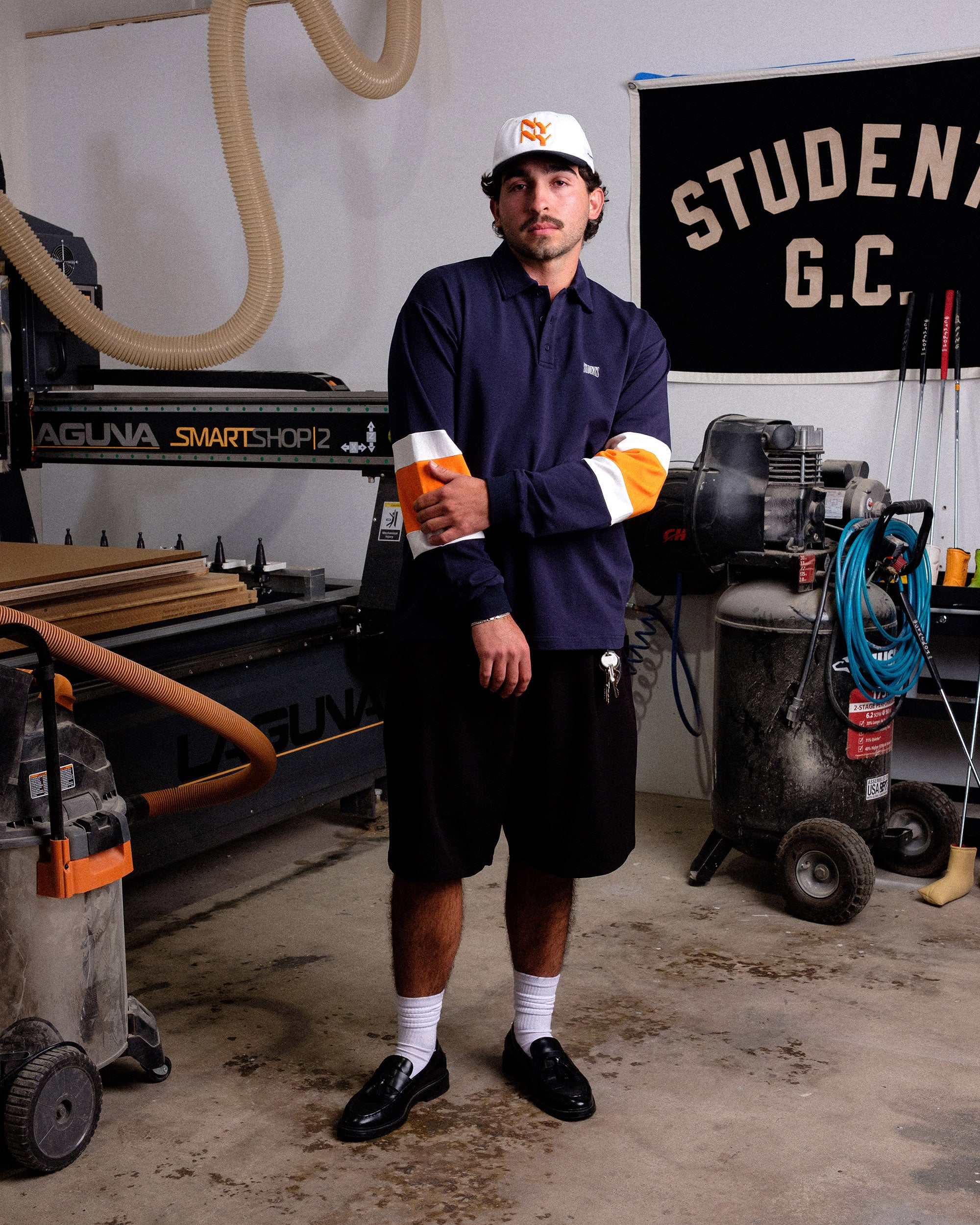 Person holding in a workshop setting with machinery and tools in the background.