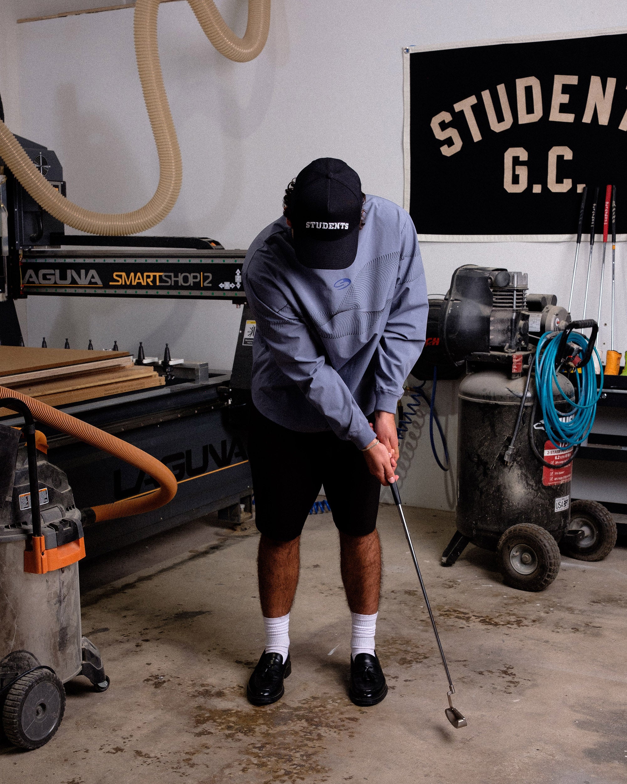 Person practicing golf swings in a workshop setting 
