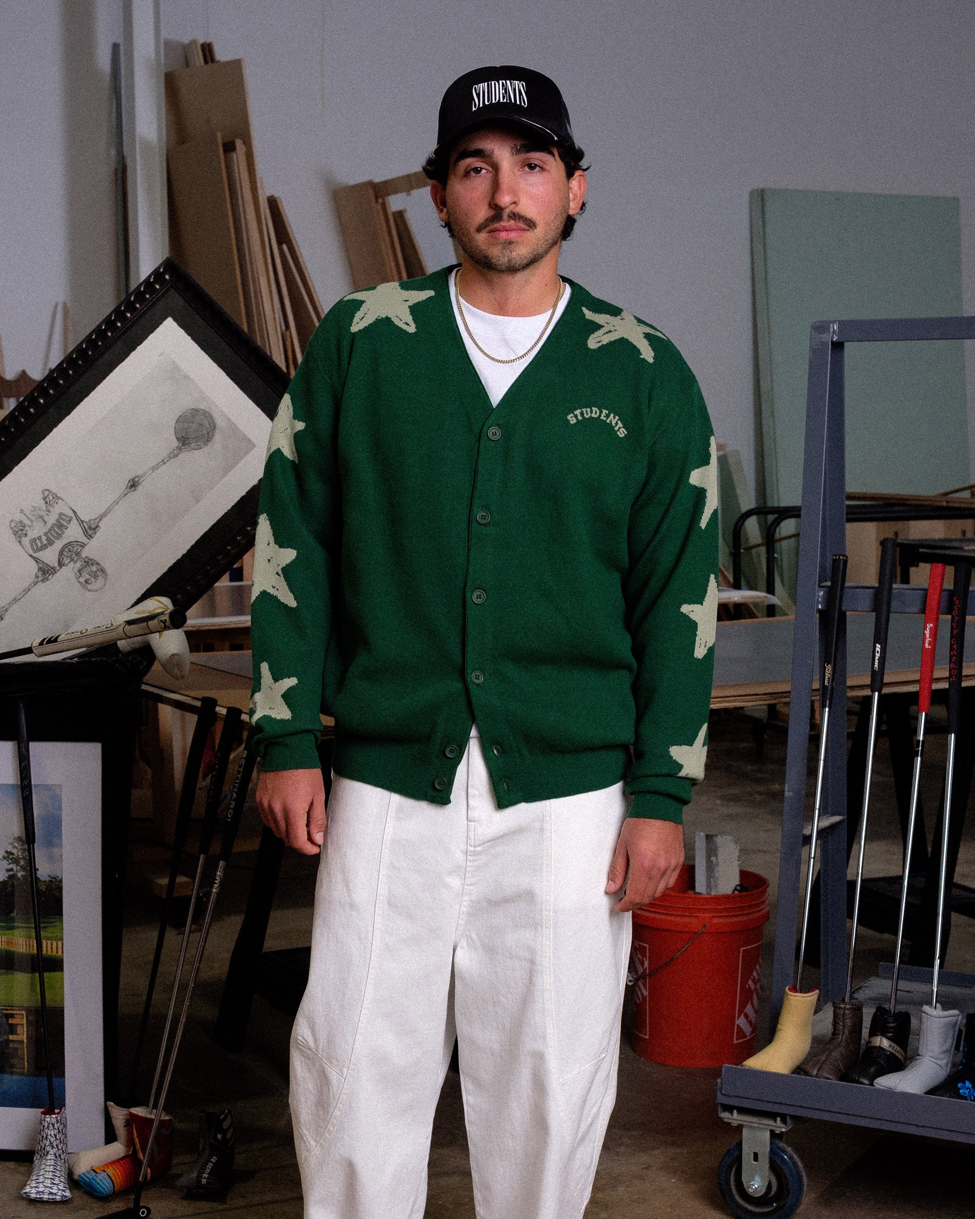Person wearing a green cardigan with star patterns in an indoor setting