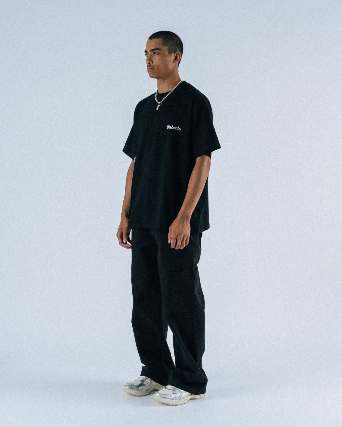 Person wearing a black t-shirt and pants on a white background