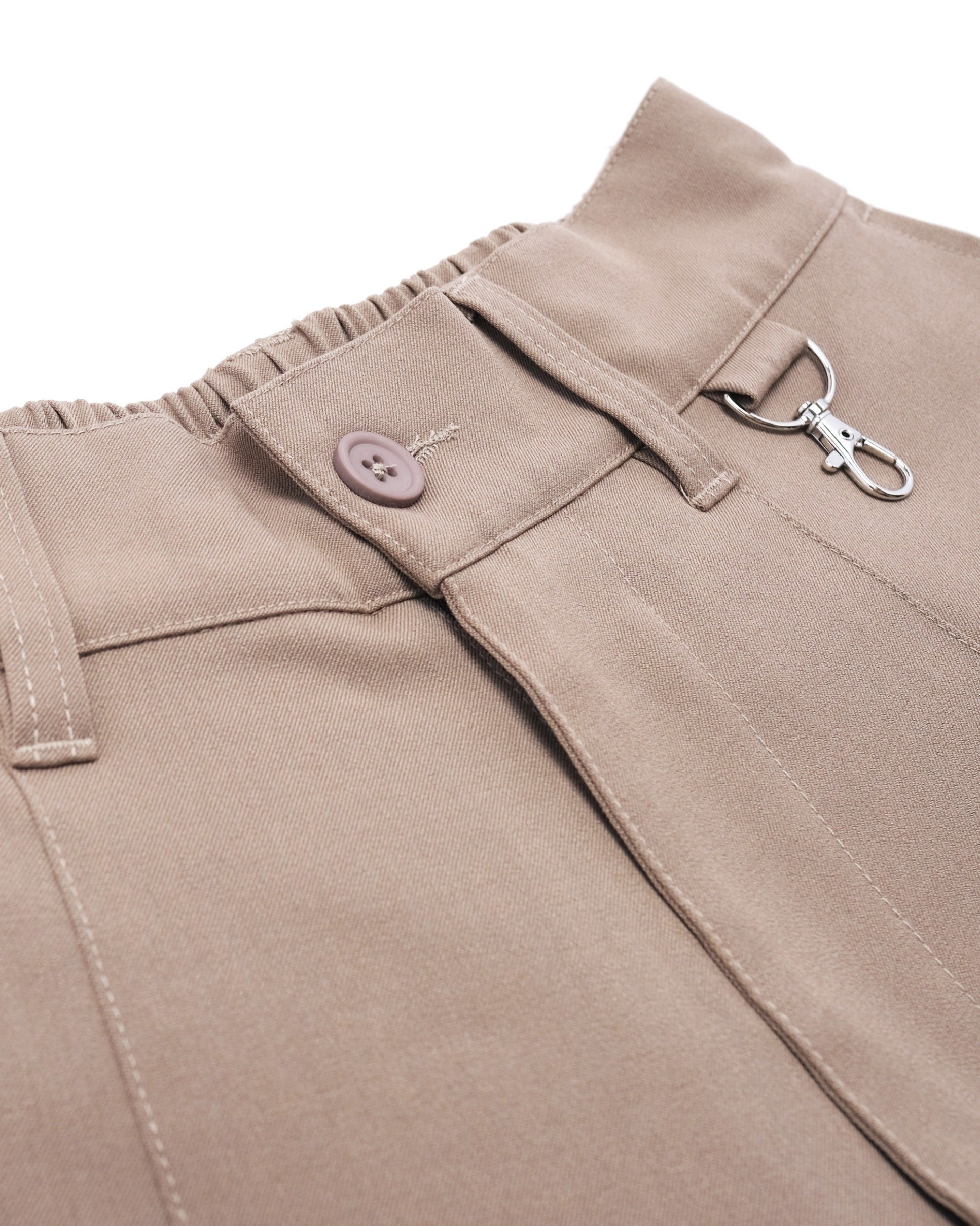 Close-up of beige pants with a button and zipper on a white background