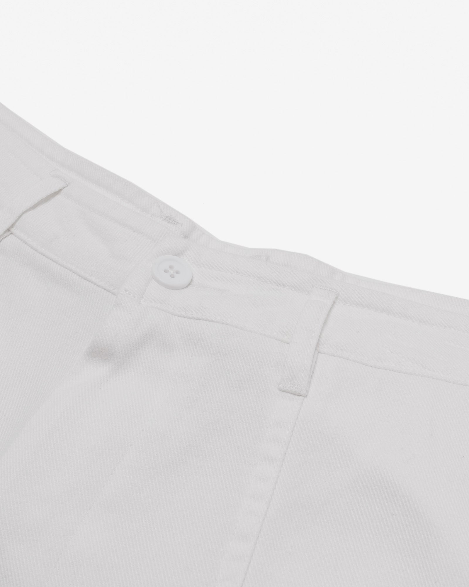 Close-up of light gray pants with a button on a white background