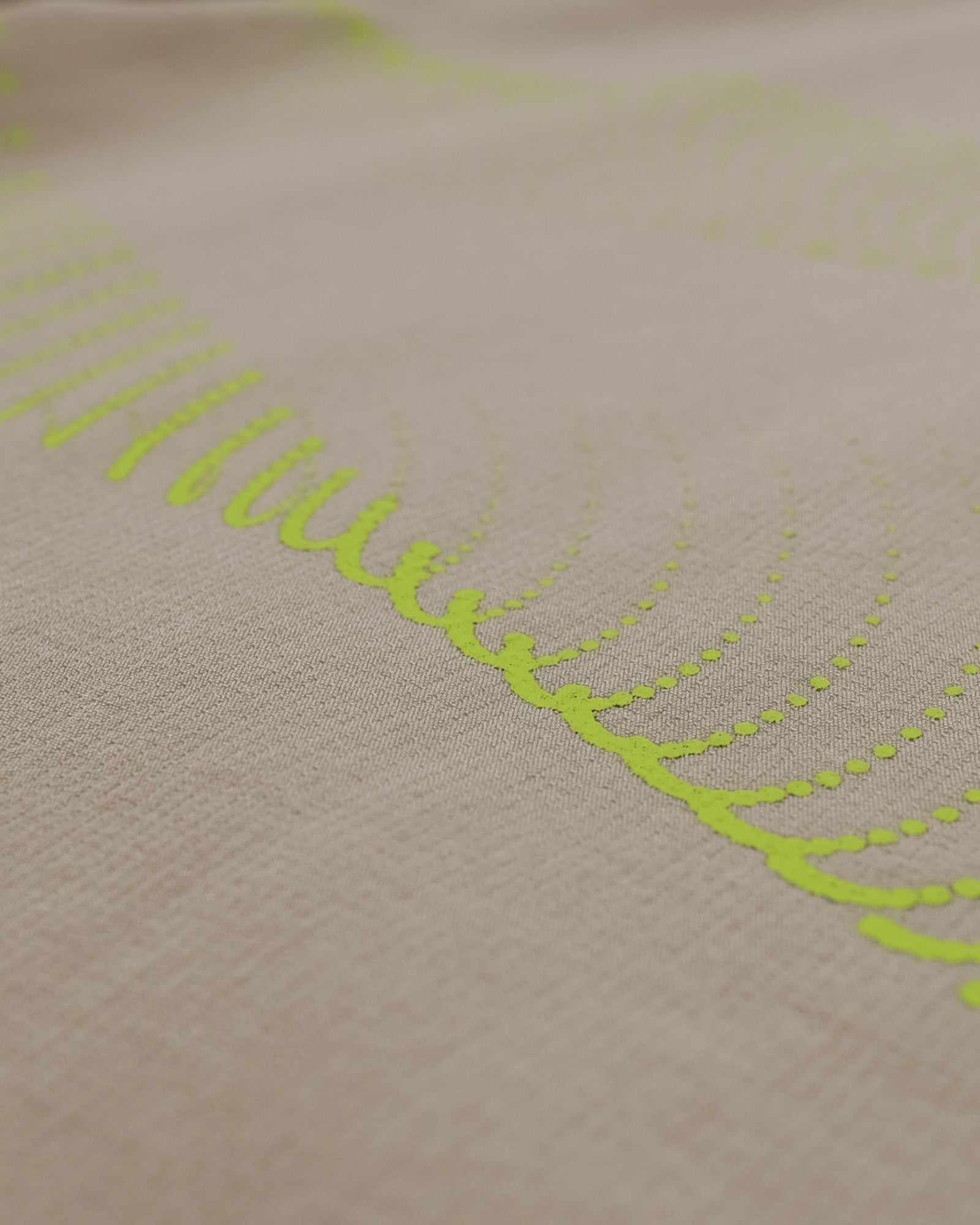 Close-up of beige fabric with green embroidered pattern