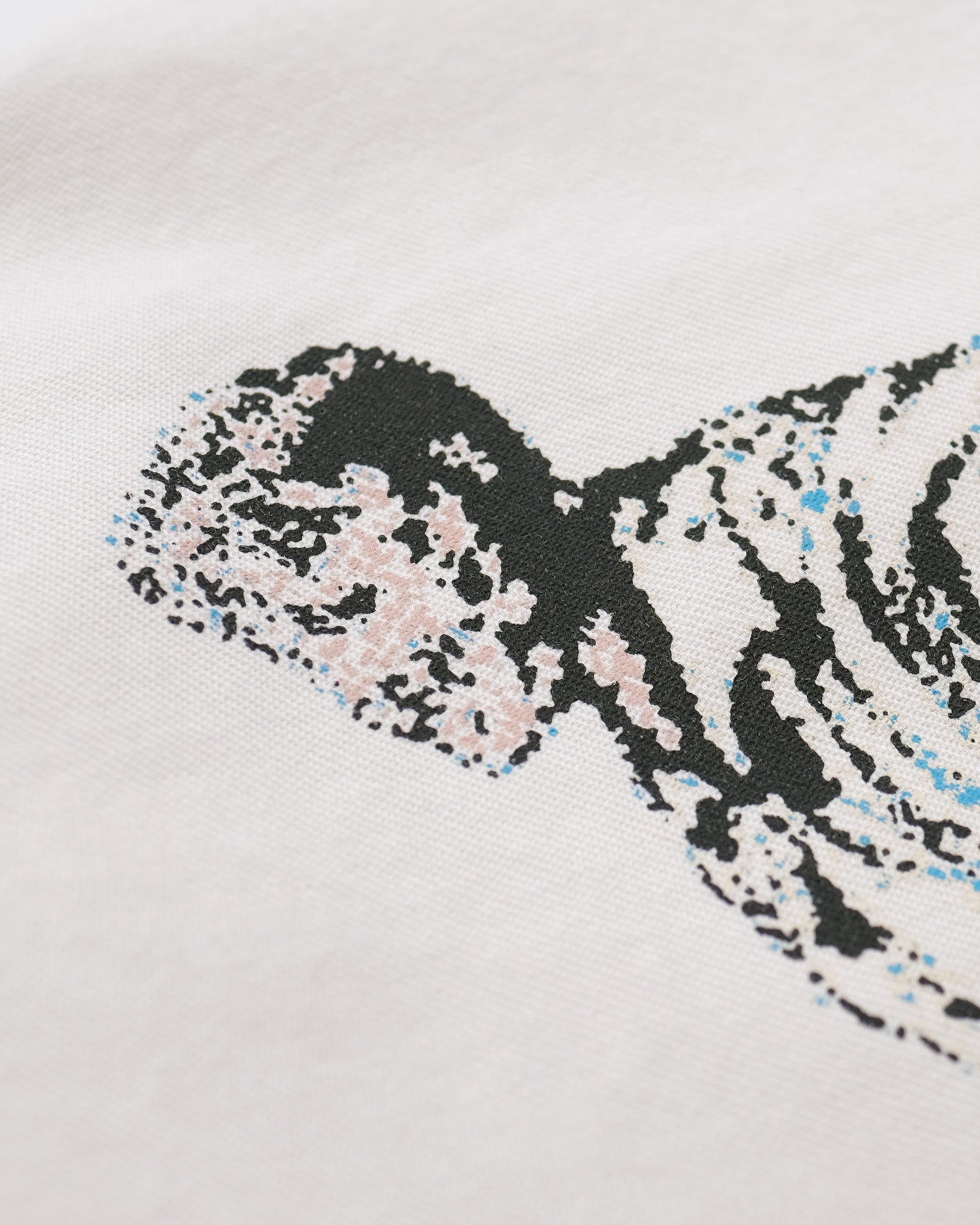 Close-up of a patterned fabric with black, white, and blue design on a light gray background