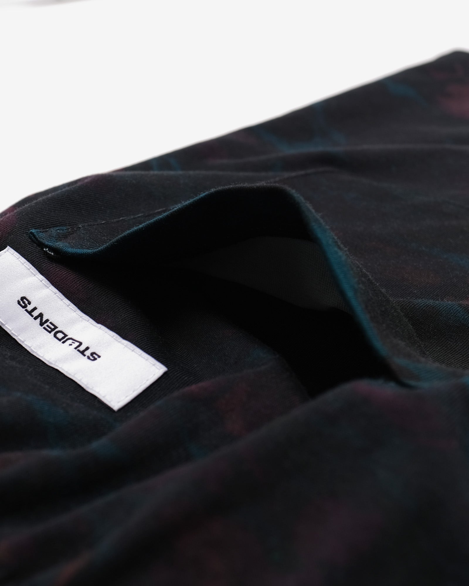 Close-up of a dark fabric with a brand label on a white background