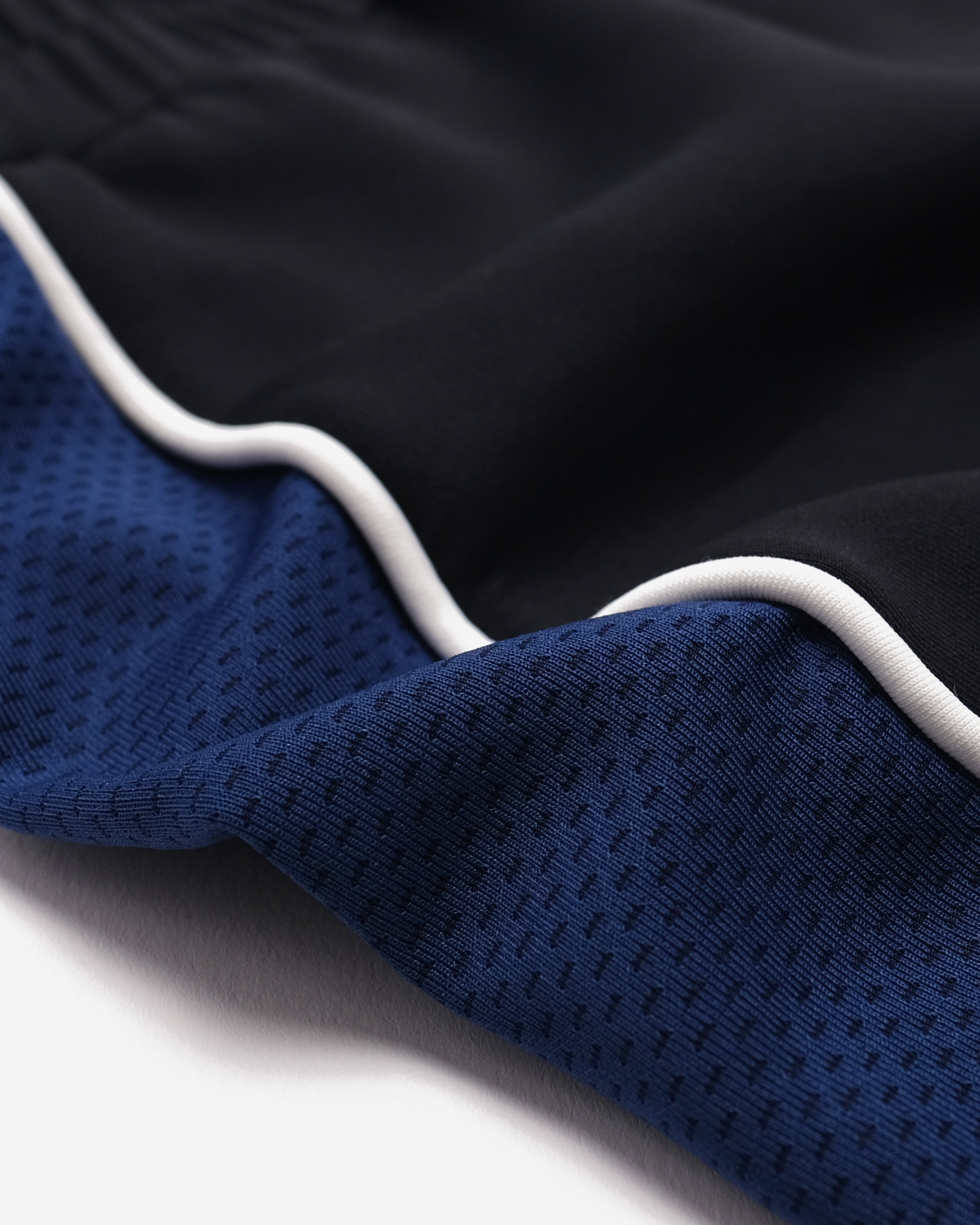 Close-up of black and blue fabric with white trim on a white background