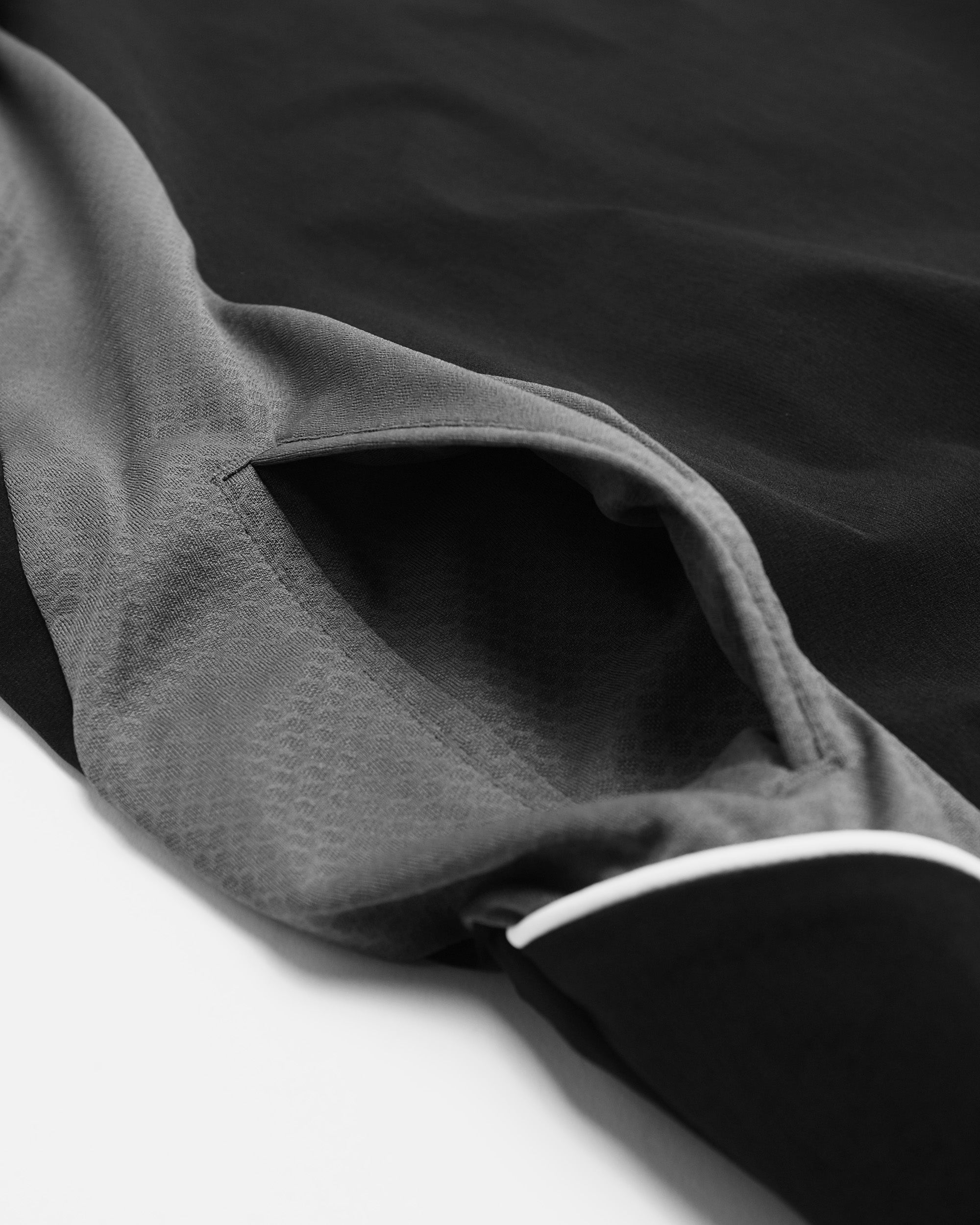 Close-up of a gray fabric with a pocket detail on a dark background