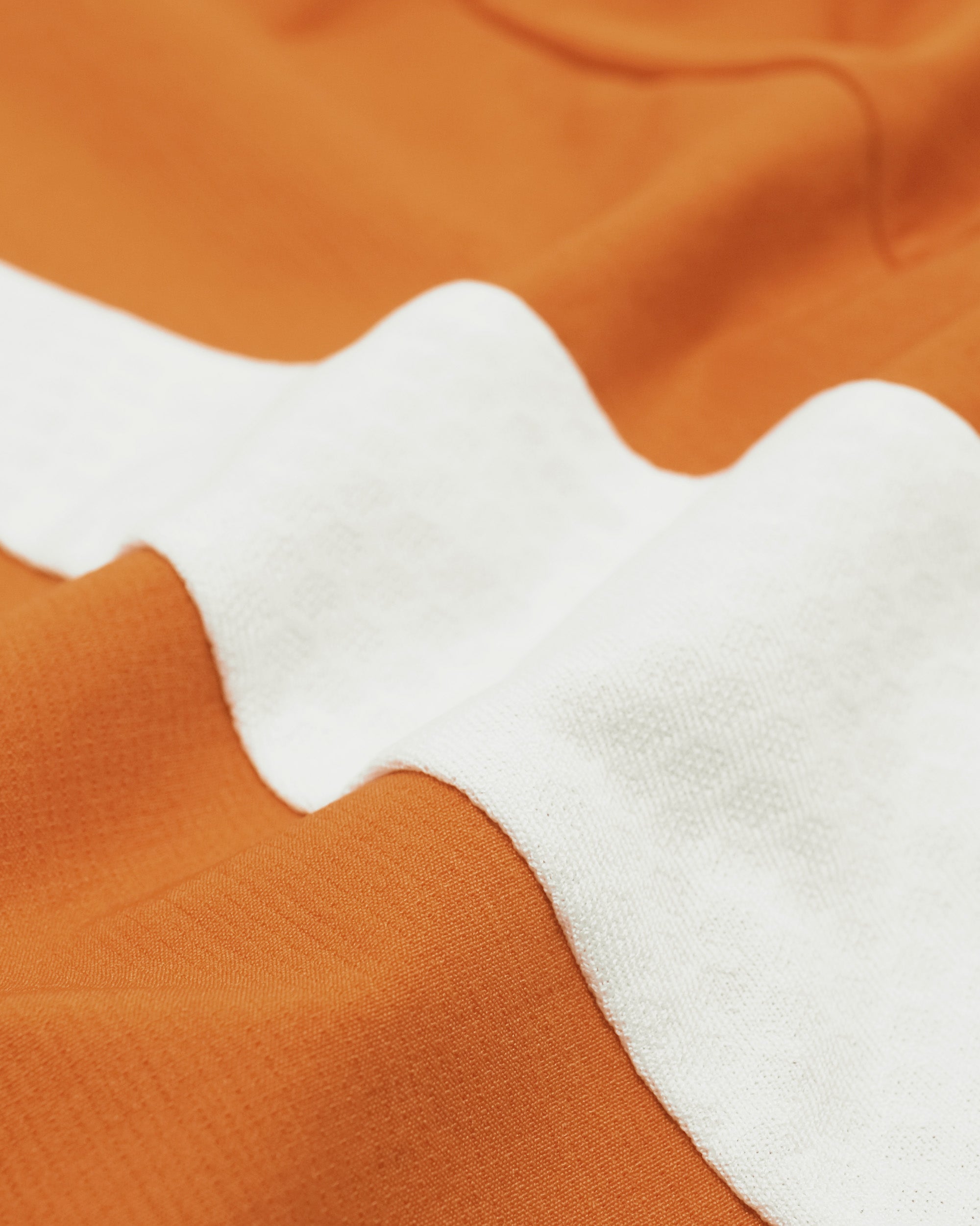 Close-up of orange fabric with white wavy pattern