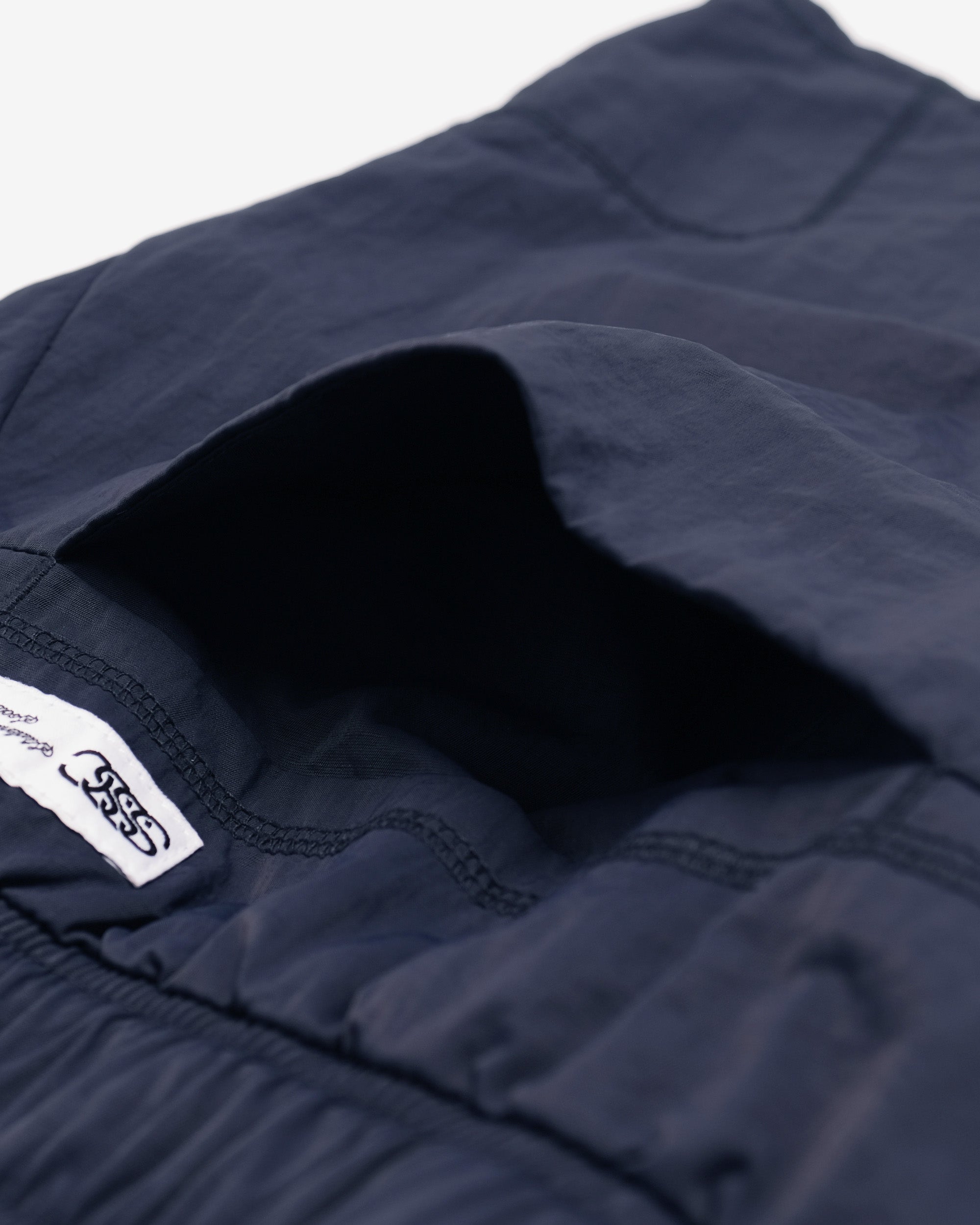 Close-up of a navy blue fabric with a brand label on a white background