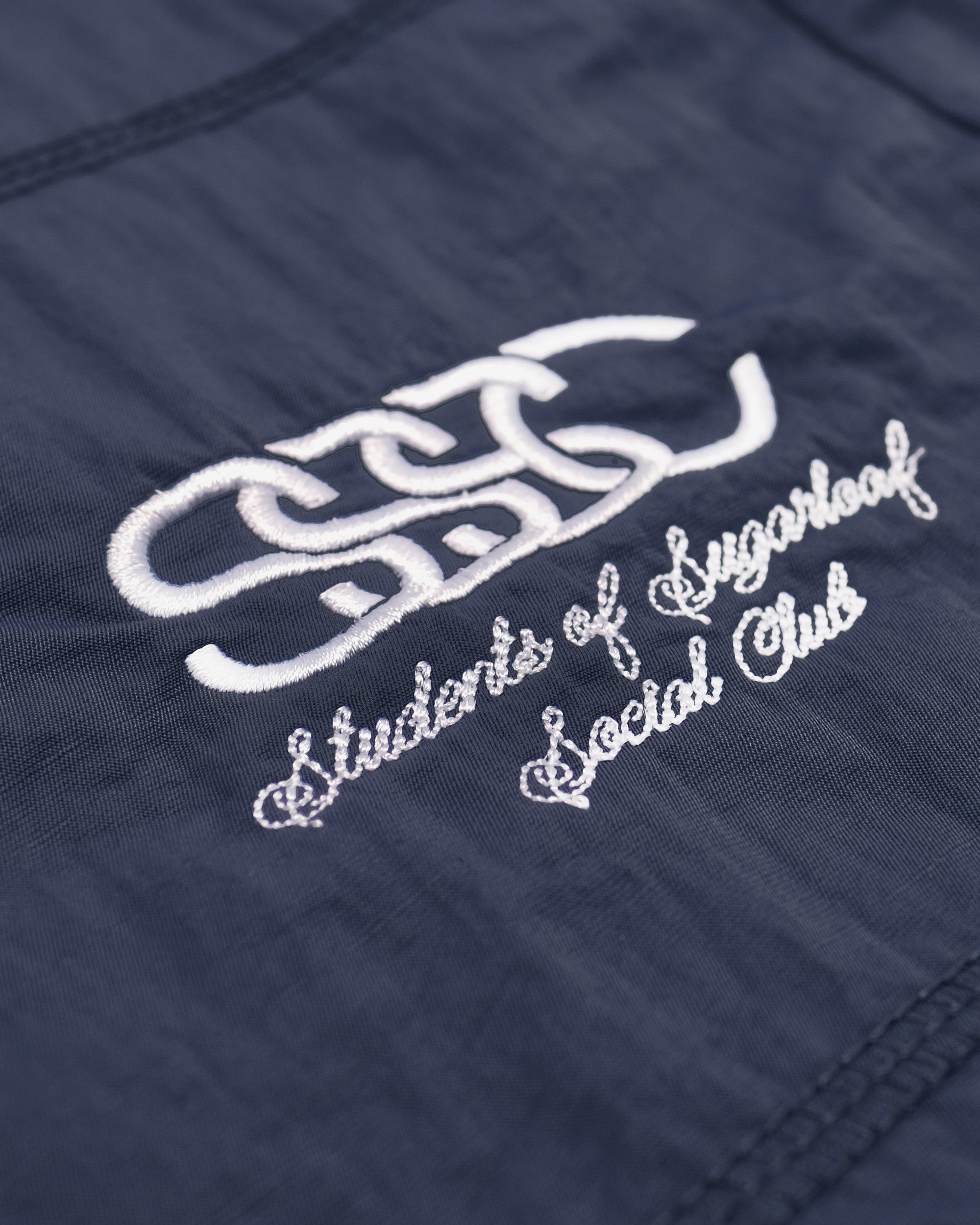 Embroidered logo on a navy blue fabric