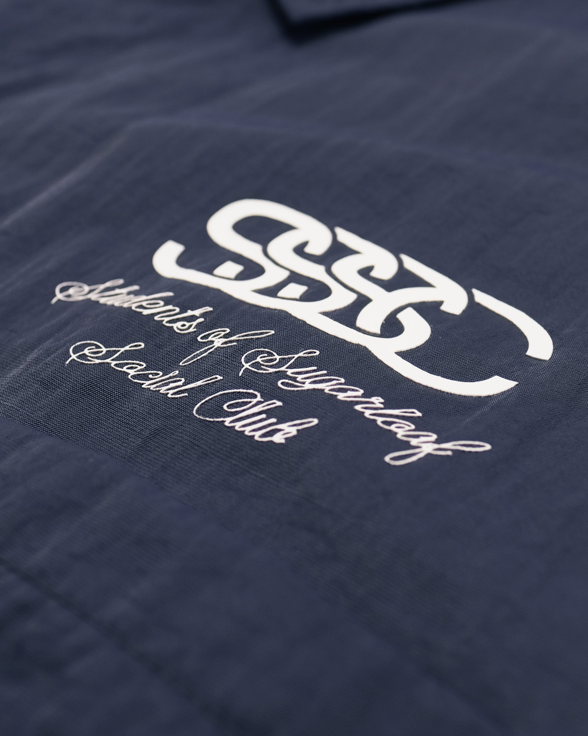 Navy blue textured fabric with white logo and text