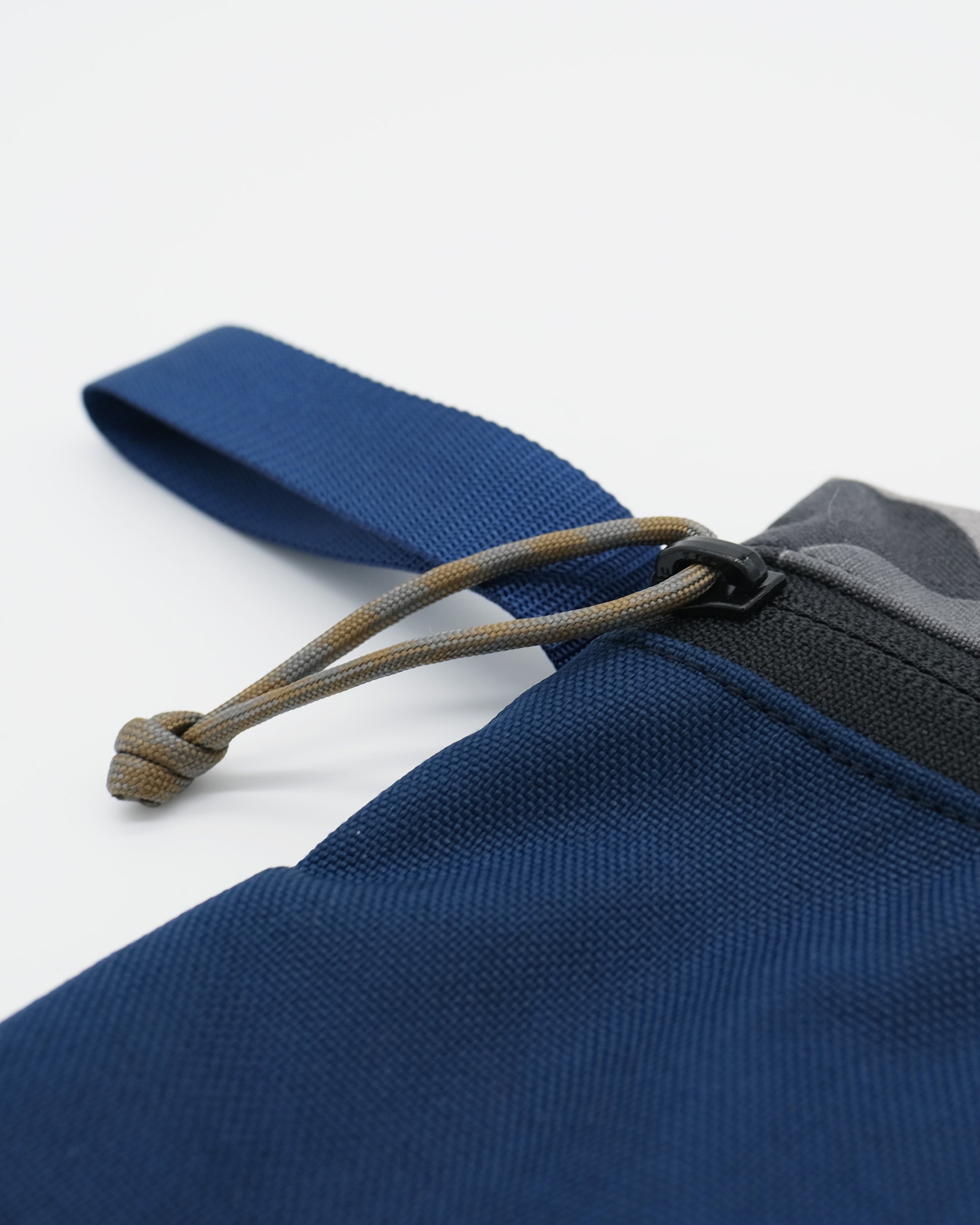 Close-up of a blue fabric with a drawstring on a white background
