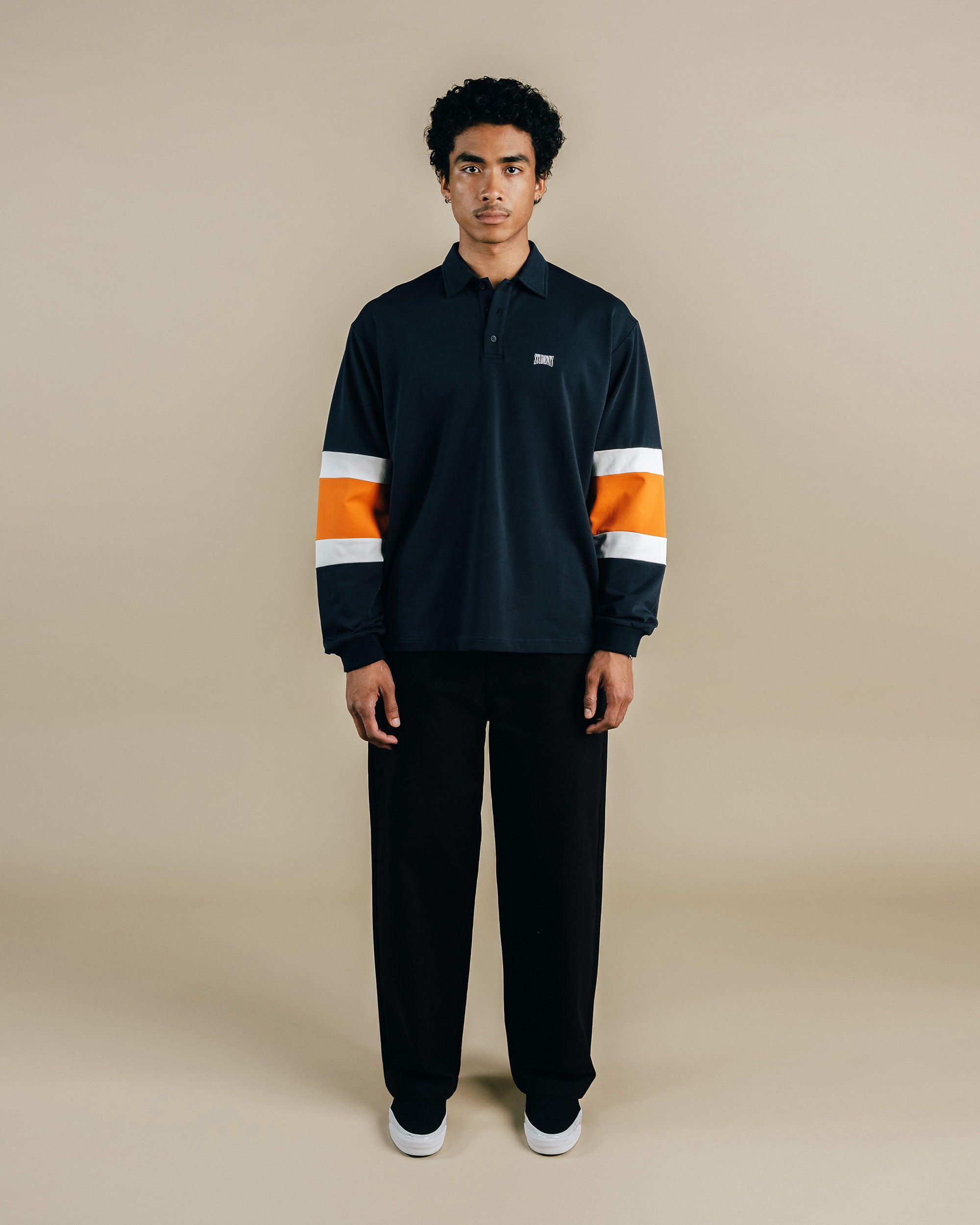 Person wearing a black and orange shirt on a beige background