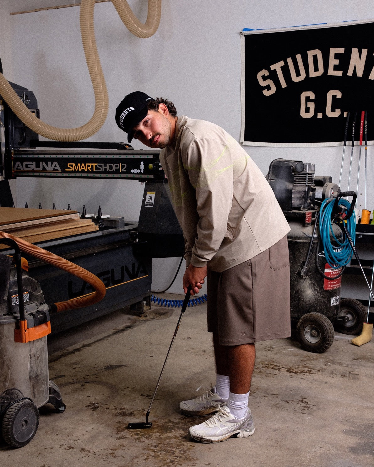 Person playing golf in a workshop with machinery and tools in the background