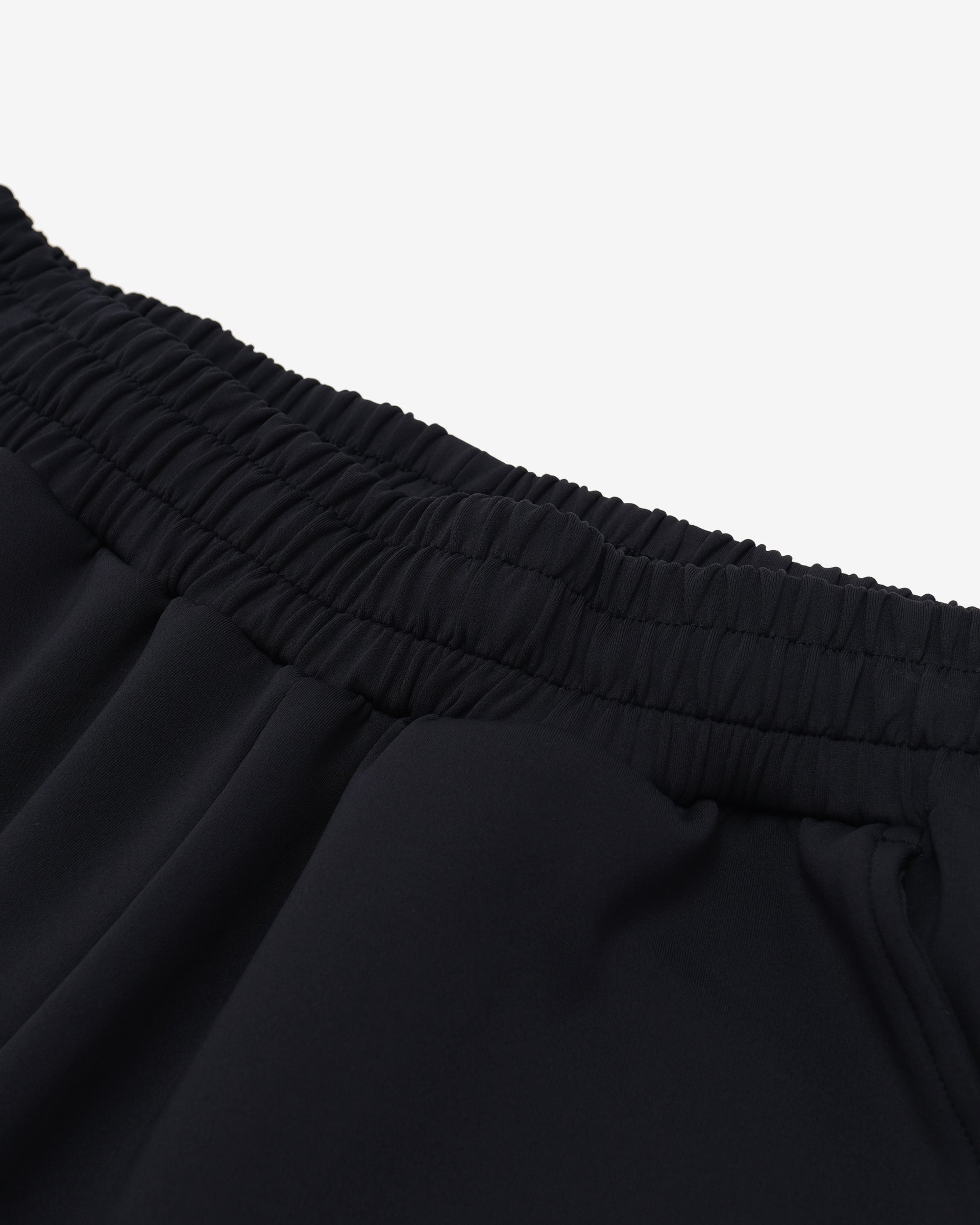 Close-up of black pants with an elastic waistband on a white background