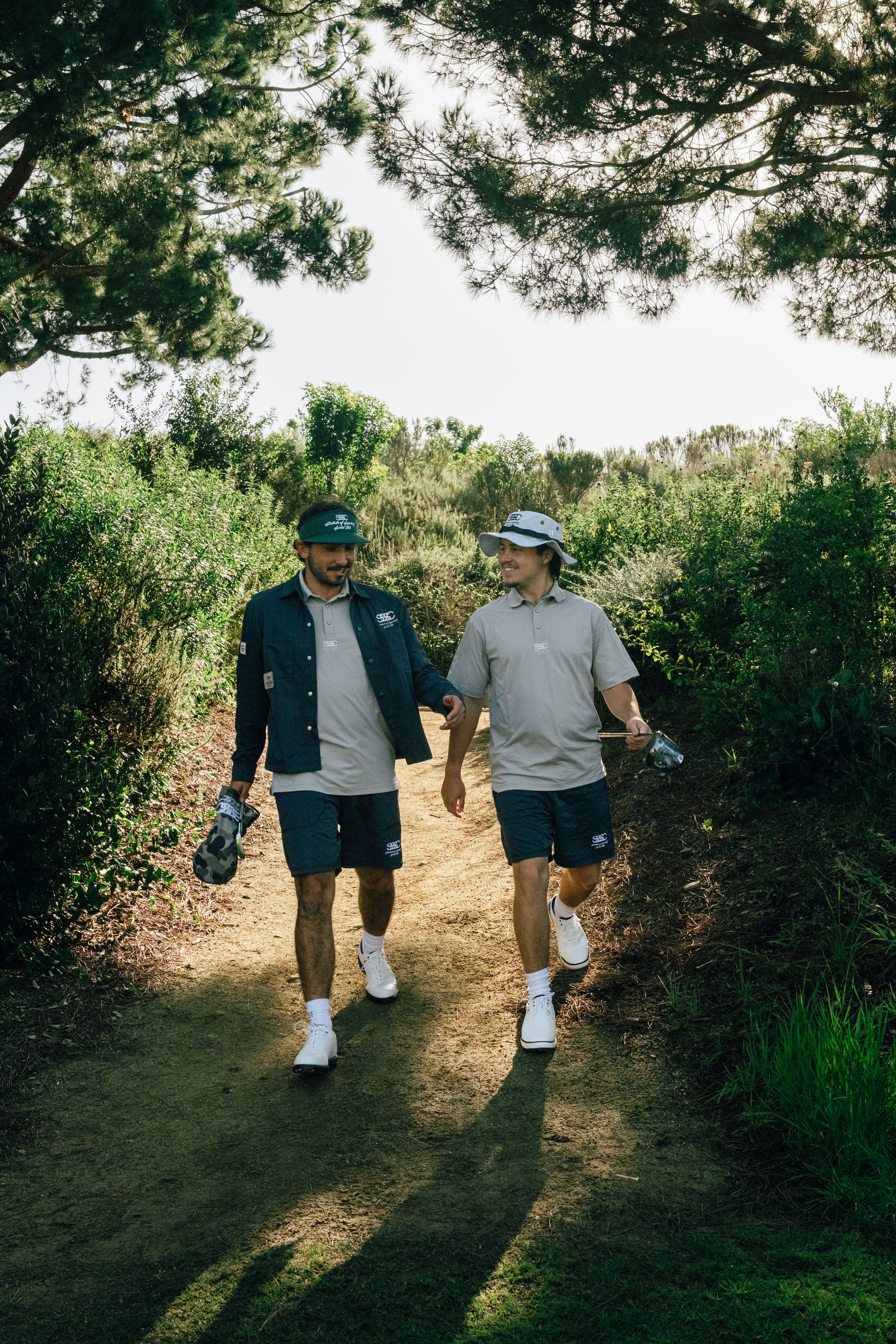 Two men walking on a path in a forested area